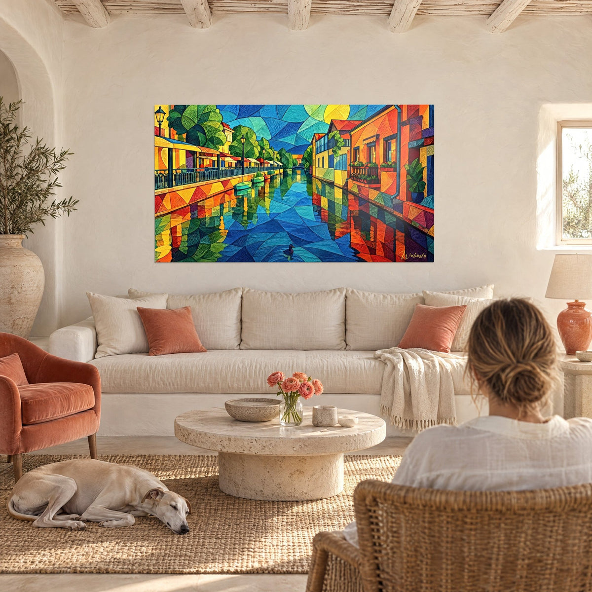 Schilderij kanaal in geometrisch mozaïek in blauw en oranje, okerkleurige en eendenblauwe gevels aan het water, boven een bank in een lichte woonkamer