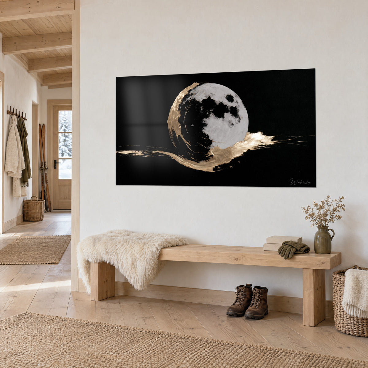 Tableau astre lunaire blanc argenté cerclé d'un trait doré sur fond noir, mur crème, banc en bois et peau de mouton, entrée chalet