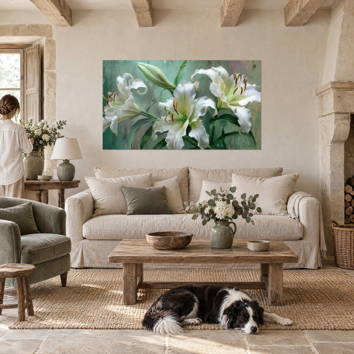 Tableau lys blancs aux pétales ondulés sur fond vert sauge, collie noir et blanc couché, au-dessus d'un canapé dans un salon lumineux