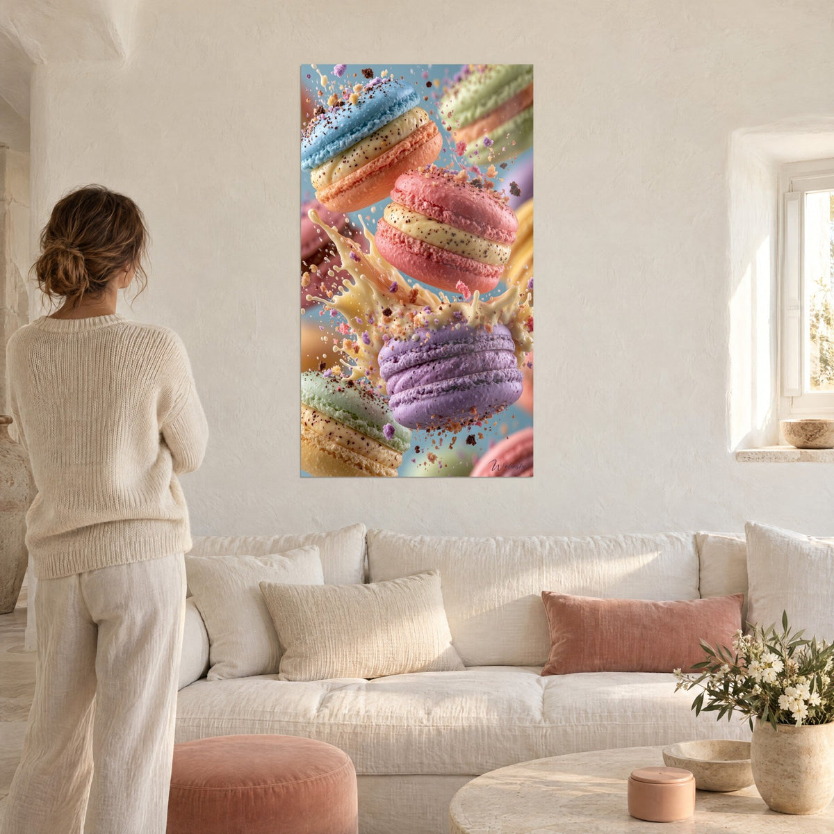 Quadro macarons pastello in caduta libera, gusci rosa corallo e malva, spruzzo di crema, donna di spalle, sopra un divano in un soggiorno luminoso