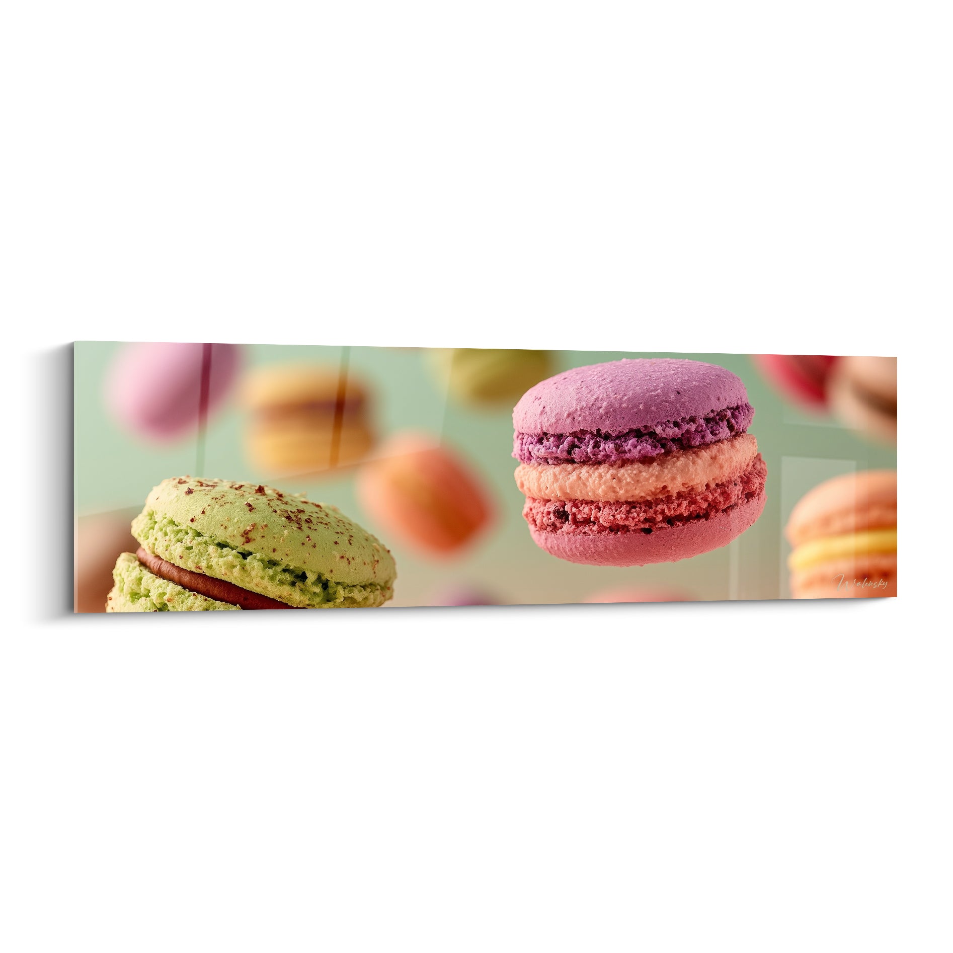 Macarons rose et pistache suspendus en plein envol sur fond vert amande flouté