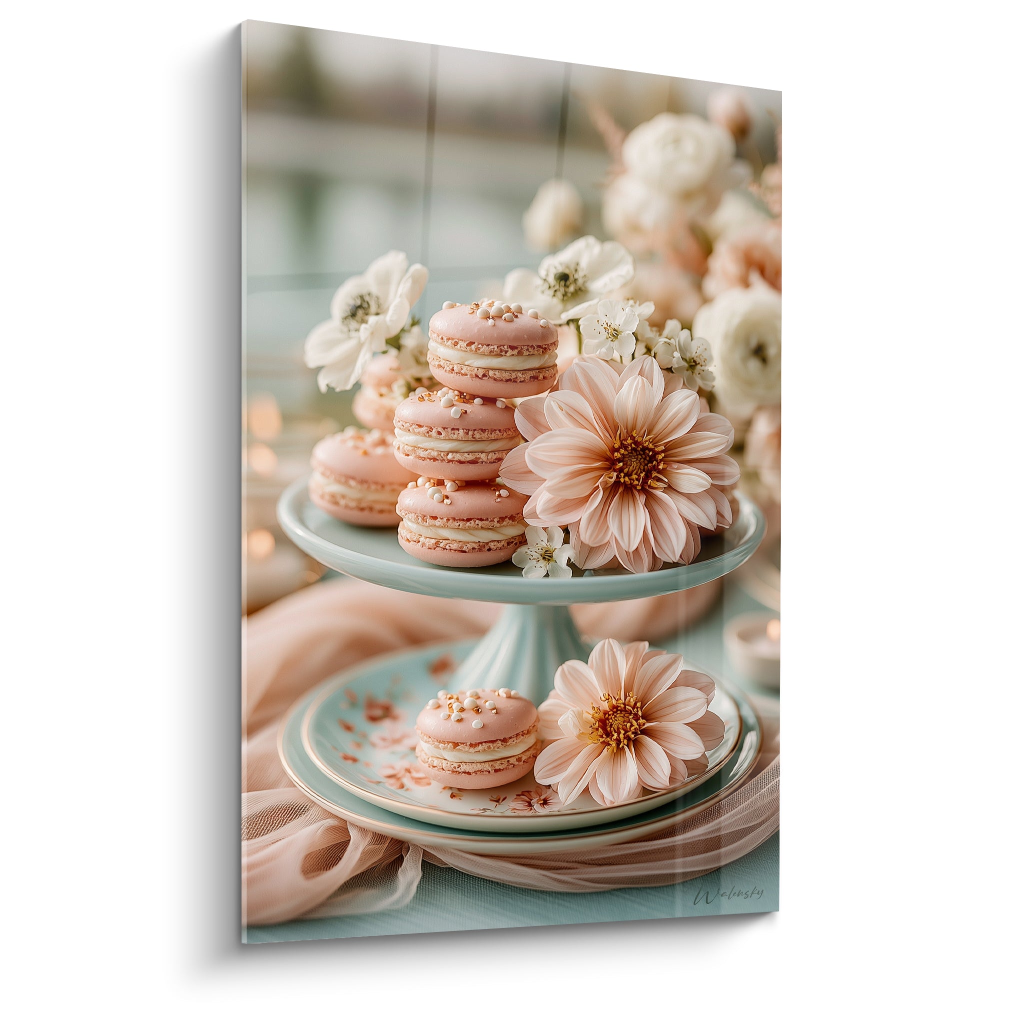 Macarons roses empilés sur présentoir vert d'eau, entourés de fleurs blanches et pêche pastel