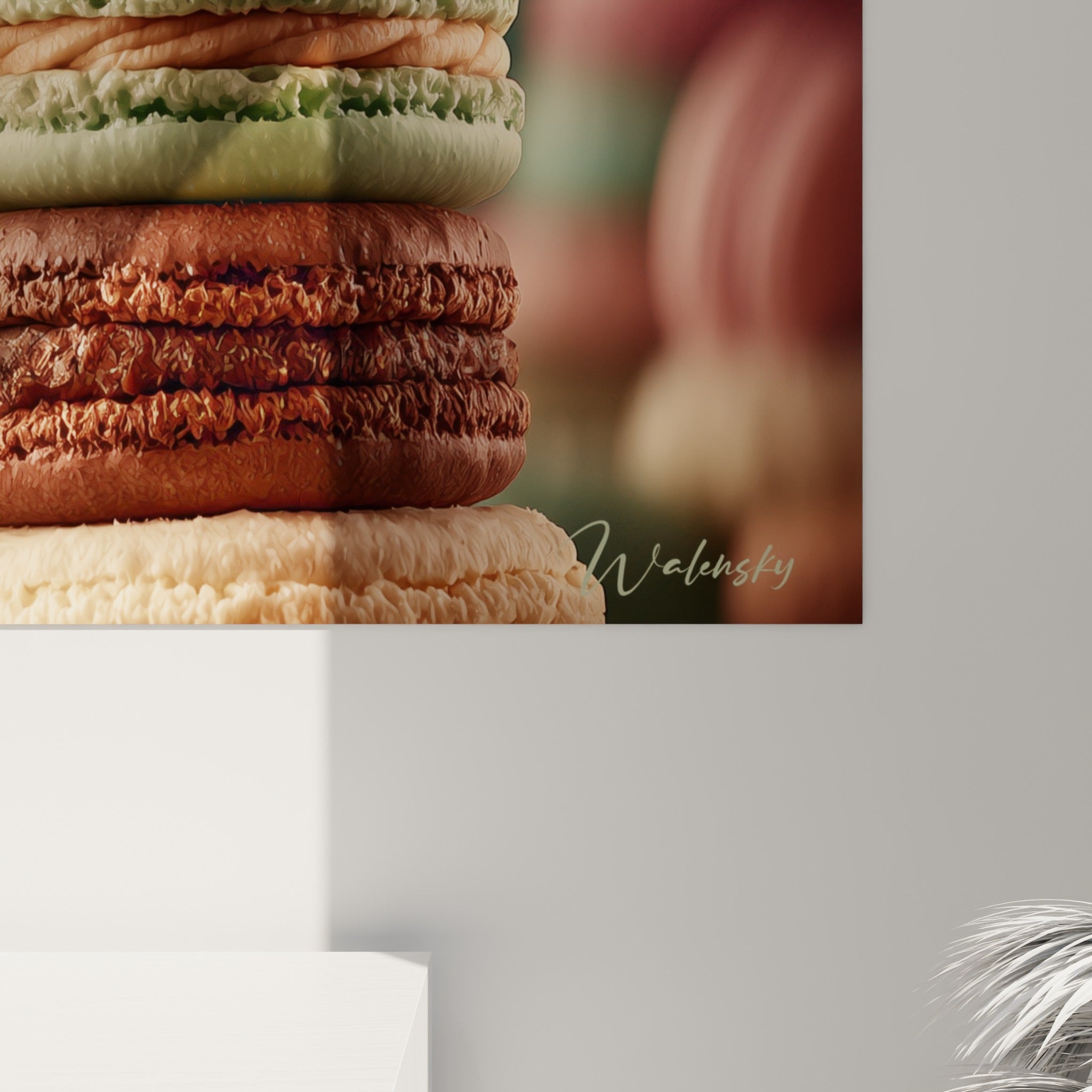 Gros plan sur la garniture crémeuse rose et la coque givrée vert sauge d'un macaron empilé.