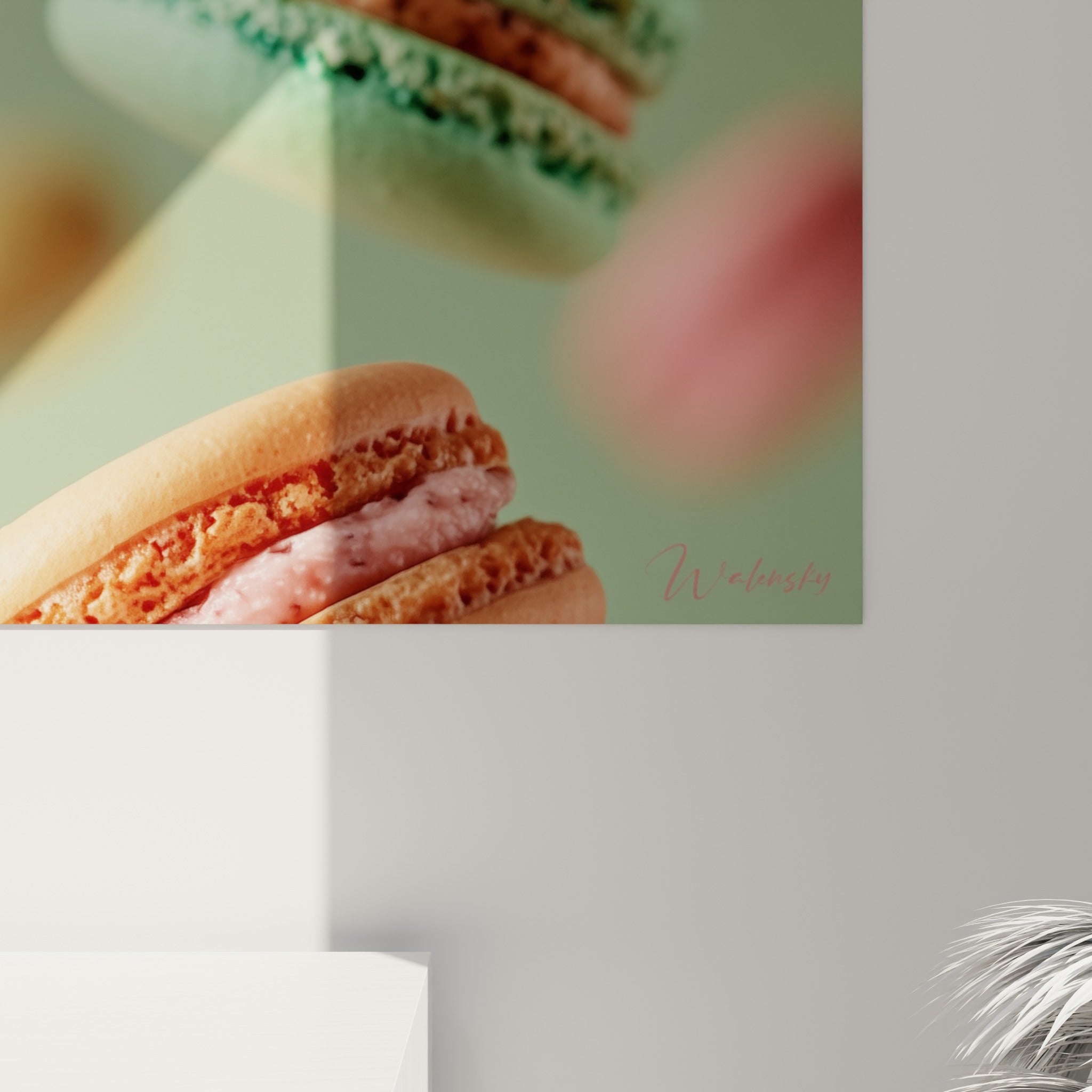 Coque granuleuse rose et garniture chocolatée du macaron central, textures craquelées et flou vert en arrière-plan