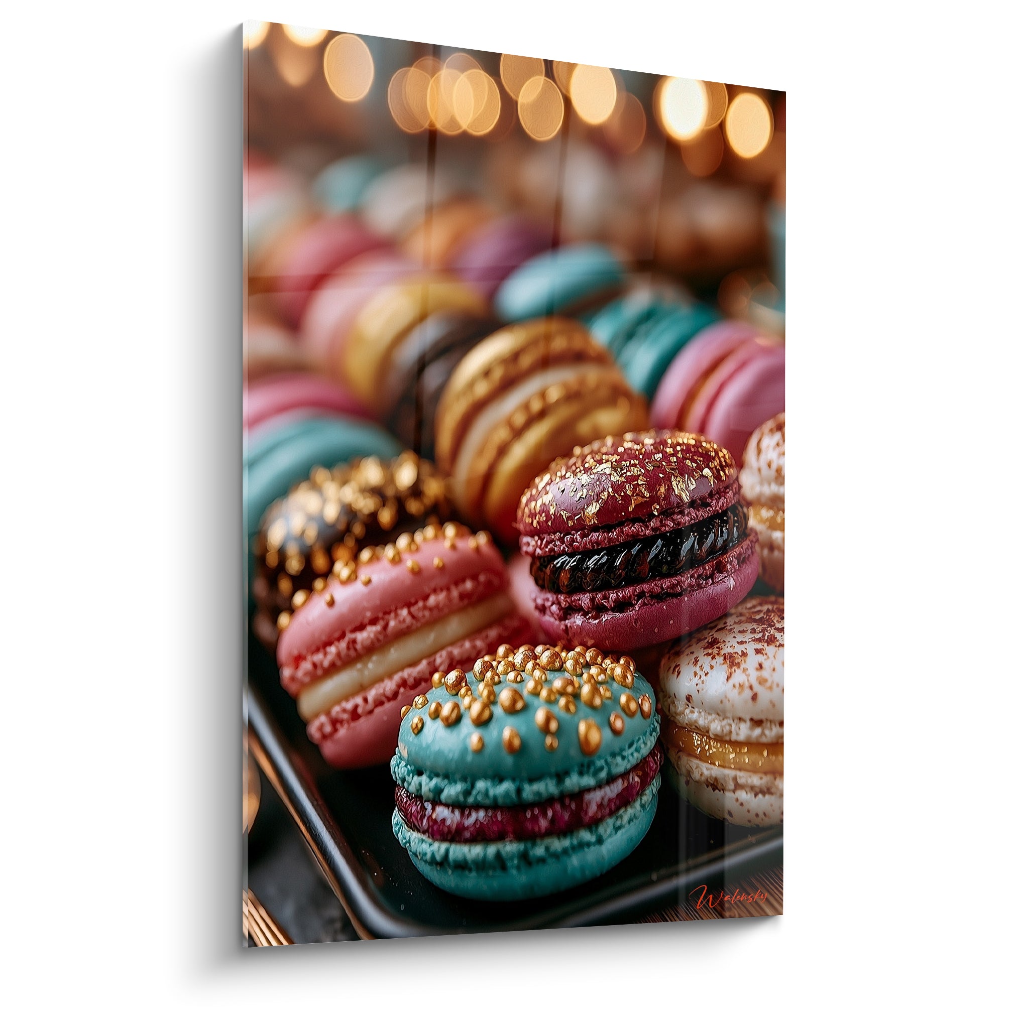 Macarons turquoise et bordeaux dorés en gros plan sur plateau noir, lumières floues dorées à l'arrière-plan
