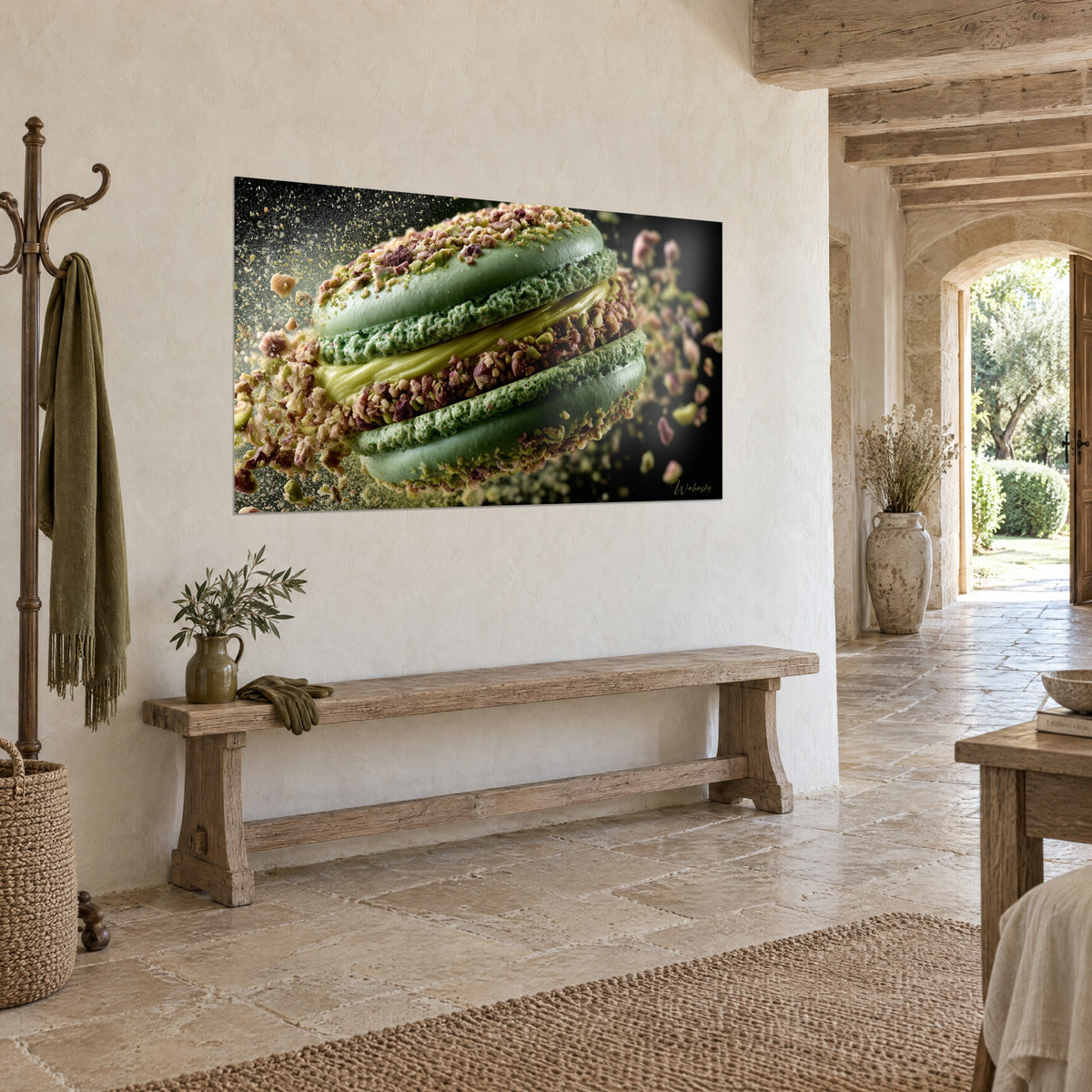 Wall art pistachio biscuit sliced open by golden ganache, sage green shells and brown powder, on a rendered wall beside a wooden bench