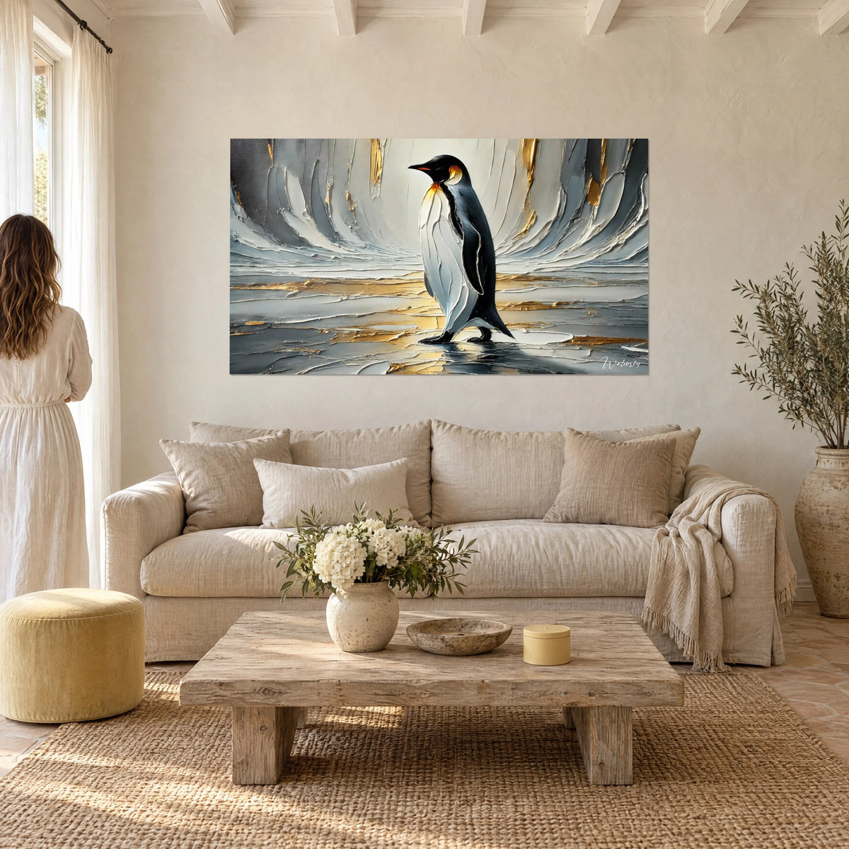 Wall art emperor penguin in white, grey and gold impasto, couple seen from behind, above a sofa in a bright living room