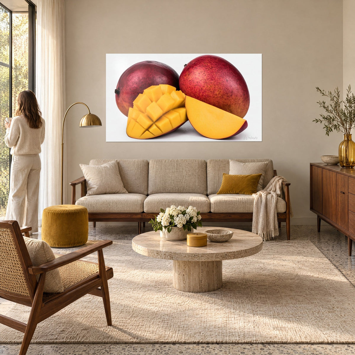 Wall art whole mangoes in purple and red, yellow flesh diced on a white background, hung above a sofa in a bright living room