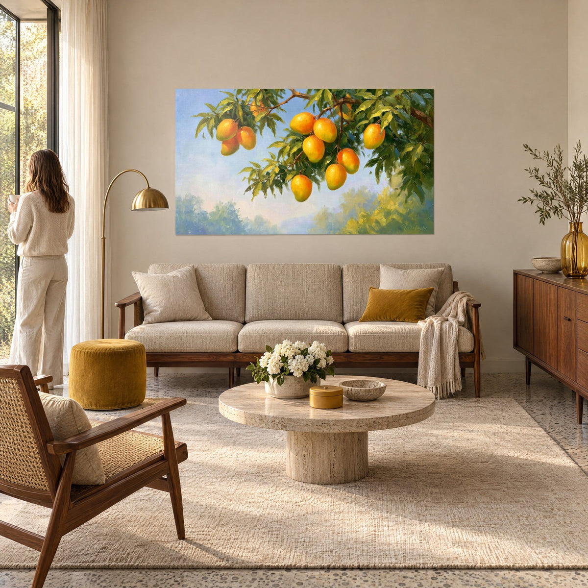 Tableau manguier ployant sous ses fruits orangés sur fond de ciel bleu pâle, femme de dos au-dessus d'un canapé dans un salon lumineux