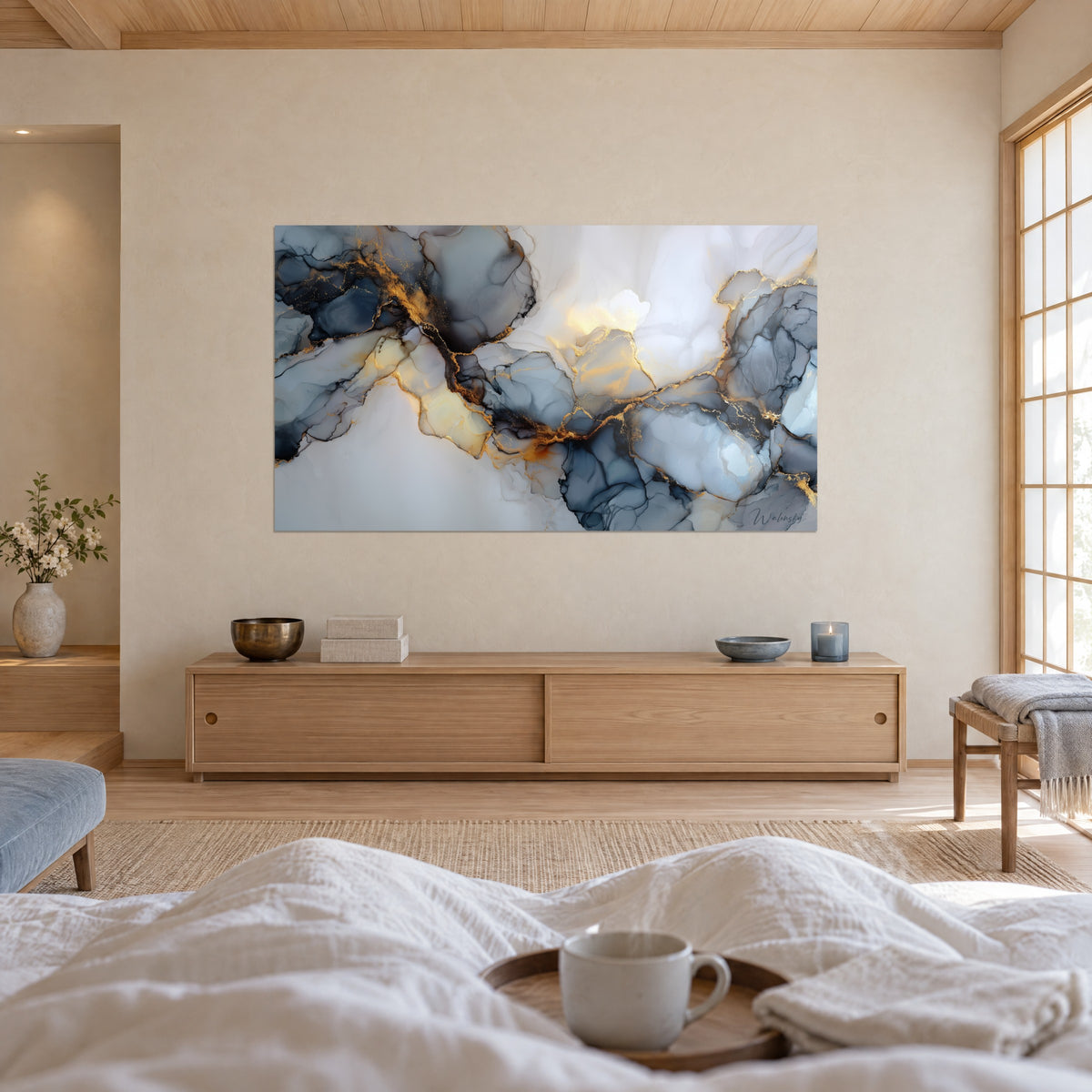 Schilderij met vloeiend mineraal patroon in nachtblauw en goud op ivoorwit, tegenover een persoon met de rug naar de kijker, boven een bed in een lichte slaapkamer