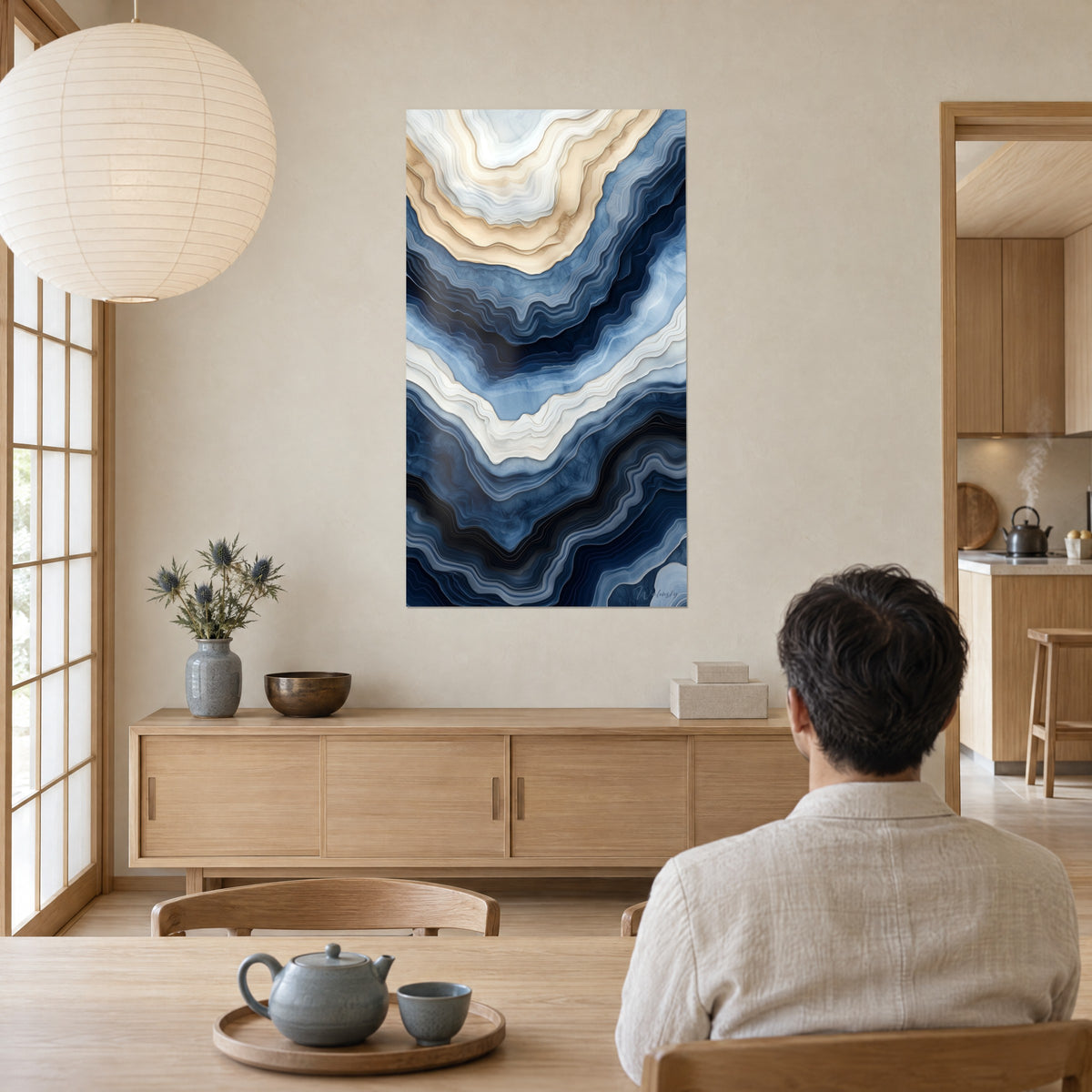Cuadro ágata estilizada en bandas fluidas azul real y beige claro, frente a la mesa donde humea un té, casa japandi