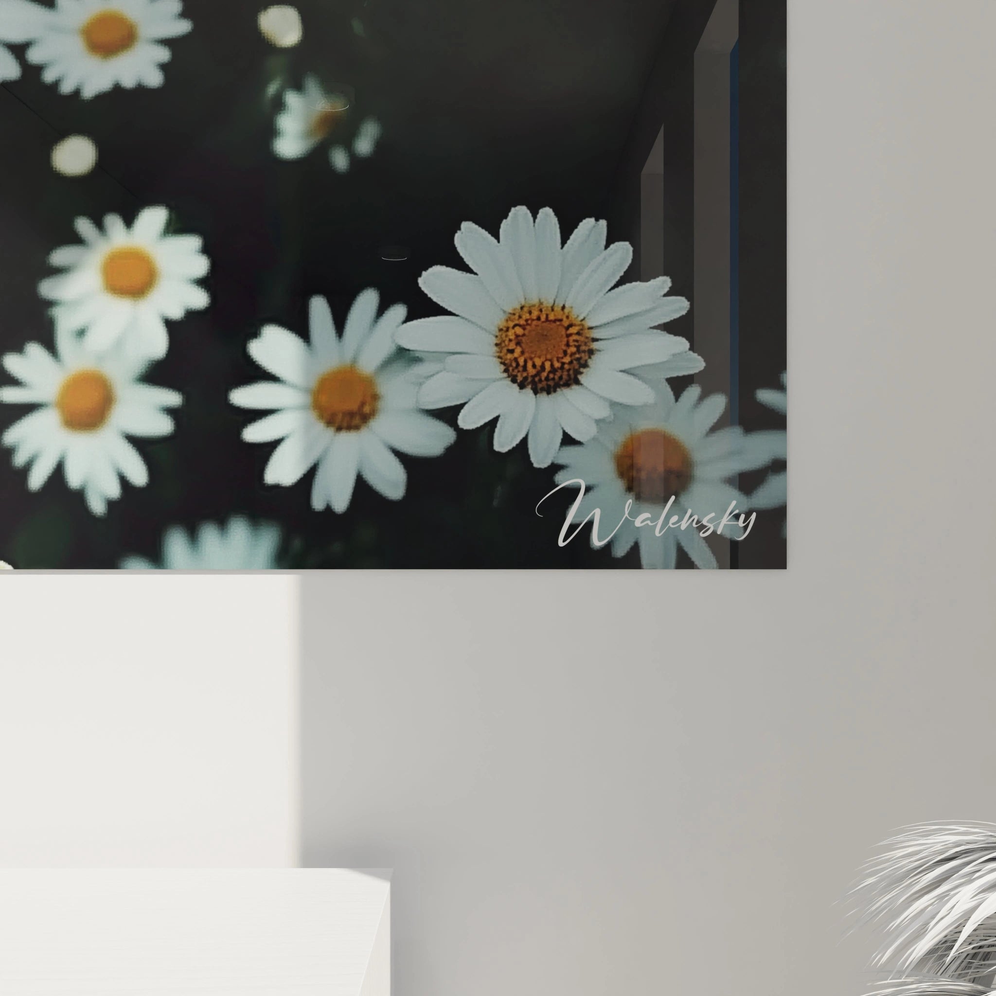 Un tableau marguerite nature capturant des fleurs blanches et jaunes dispersées sur un fond vert, avec un jeu de lumière et d’ombres créant un effet de relief subtil sur les pétales et le feuillage.