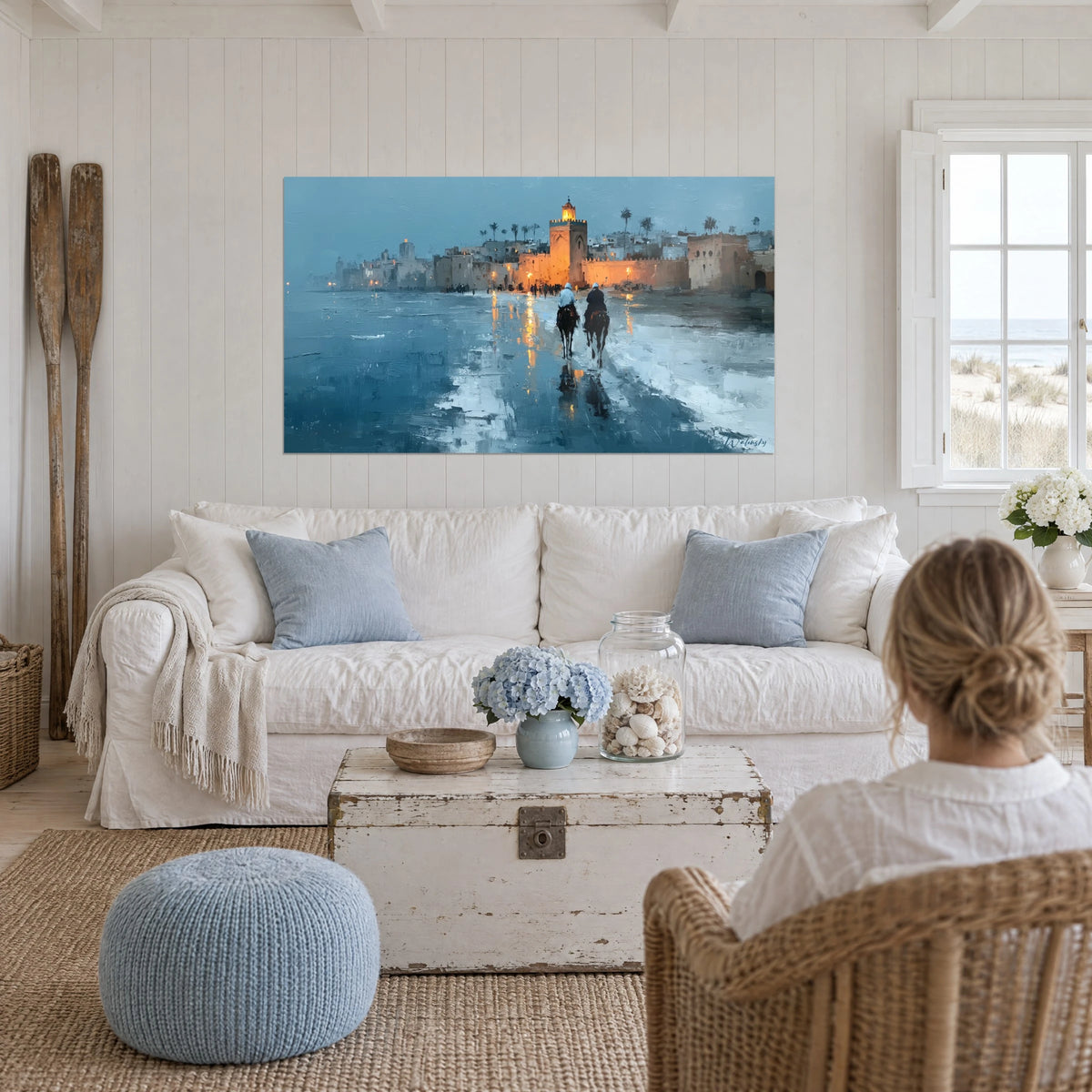 Quadro minareto arancione illuminato al crepuscolo, due cavalieri su sabbia bagnata blu, sopra un divano in un soggiorno luminoso