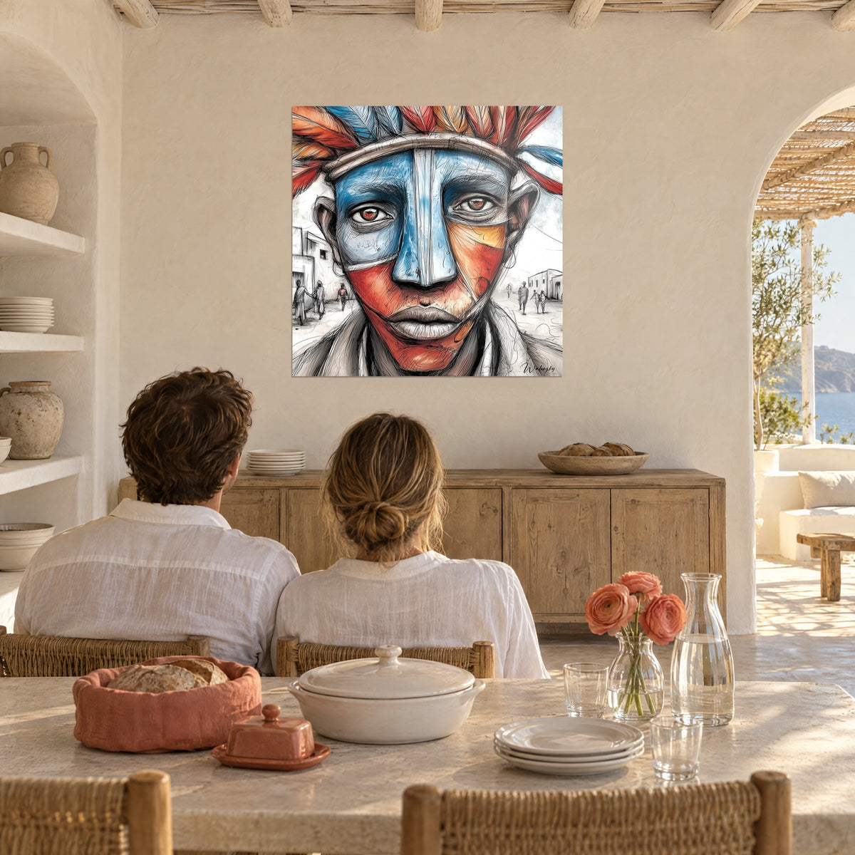 Cuadro hombre con máscara pintada en azul cielo y rojo coral, cinta de plumas, frente al rincón del comedor de una casa blanca