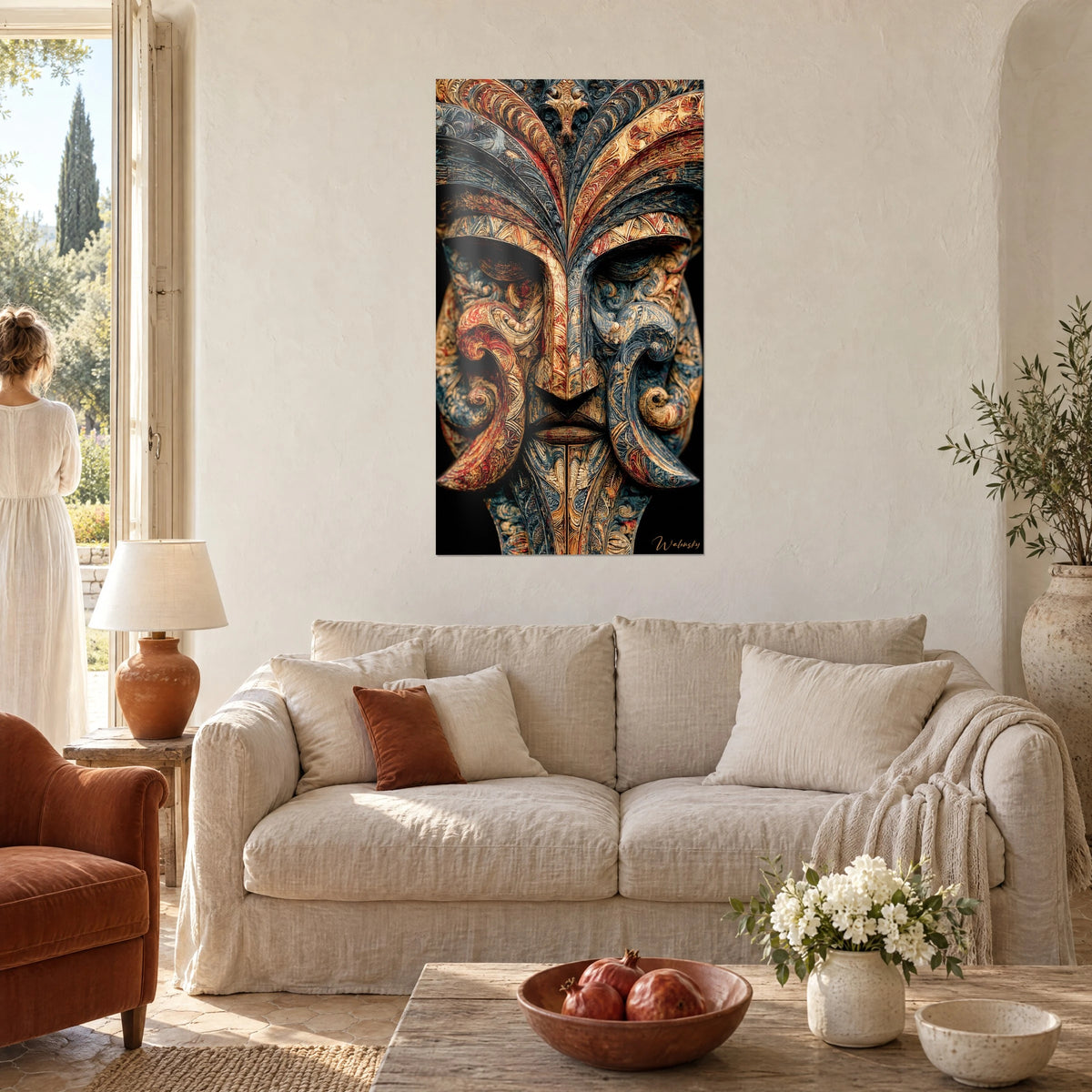 Tableau masque sculpté aux volutes bleu ardoise et rouge brique, plumes dorées en éventail, au-dessus d'un canapé dans un salon lumineux