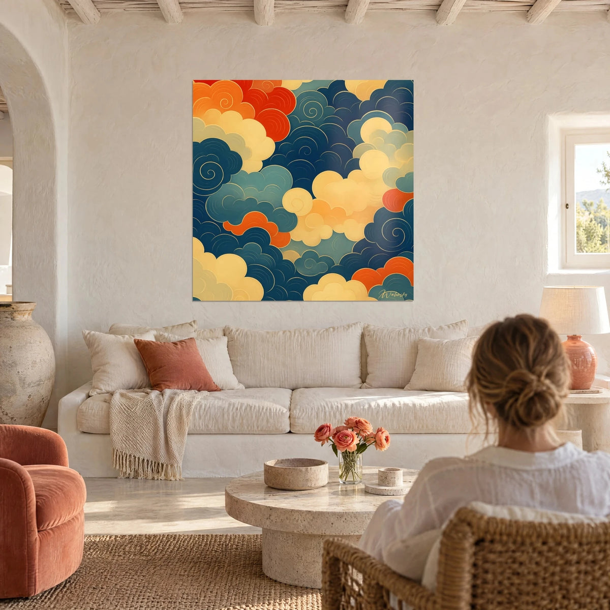 Cuadro nubes japonesas en espirales azul marino y naranja vivo, filetes dorados, mujer de espaldas sobre un sofá en un salón luminoso