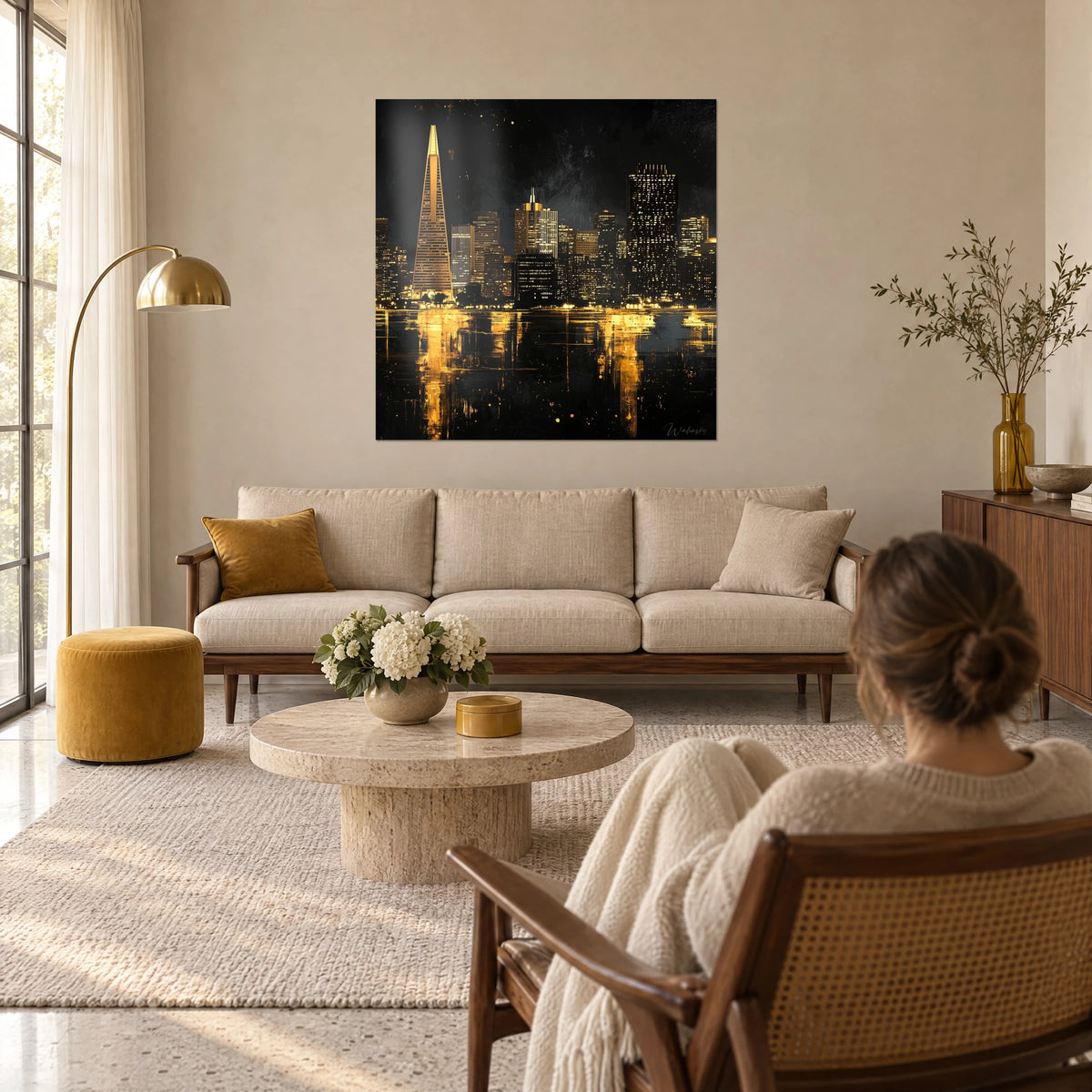 Tableau gratte-ciel dorés se reflétant sur l'eau noire, pyramide ambrée et femme de dos, au-dessus d'un canapé dans un salon lumineux