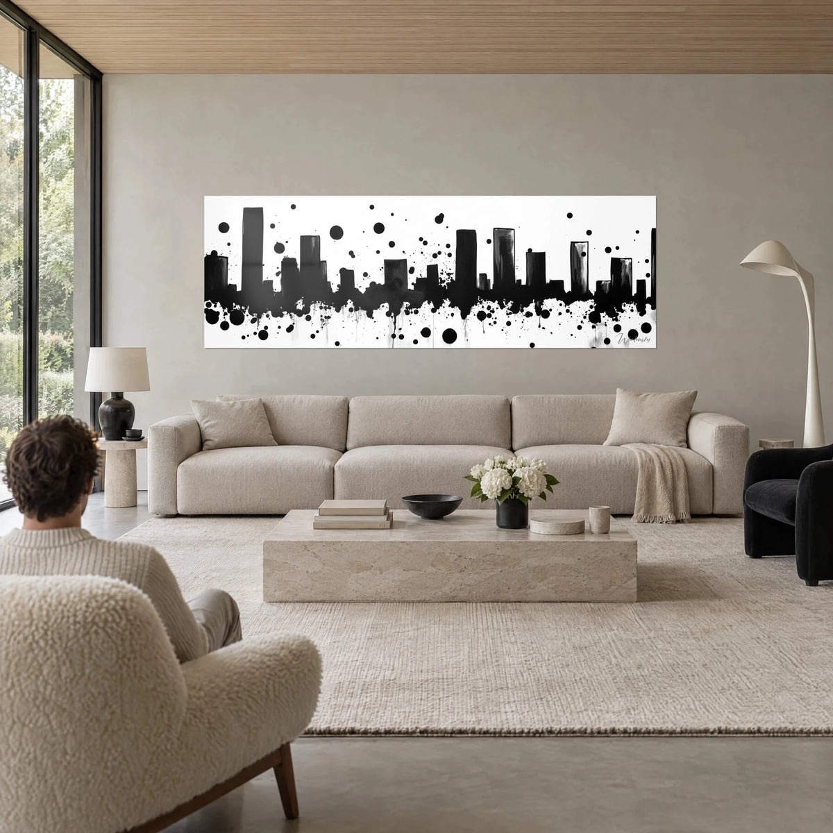 Wall art skyline of black towers on a white background, ink splashes and graphite grey, above a sofa in a bright living room