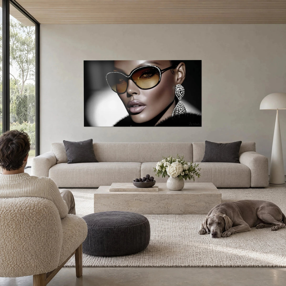 Cuadro de modelo con gafas ámbar y pendiente de strass, fondo blanco y negro, encima de un sofá en un salón luminoso