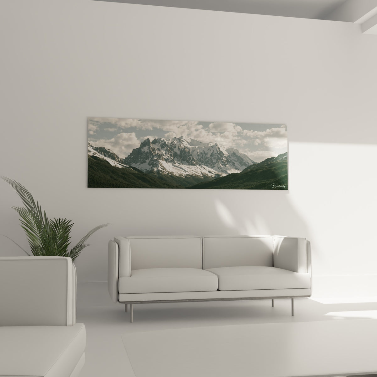 Panorama de crêtes enneigées et forêt vert sombre au-dessus d'un canapé dans un salon lumineux