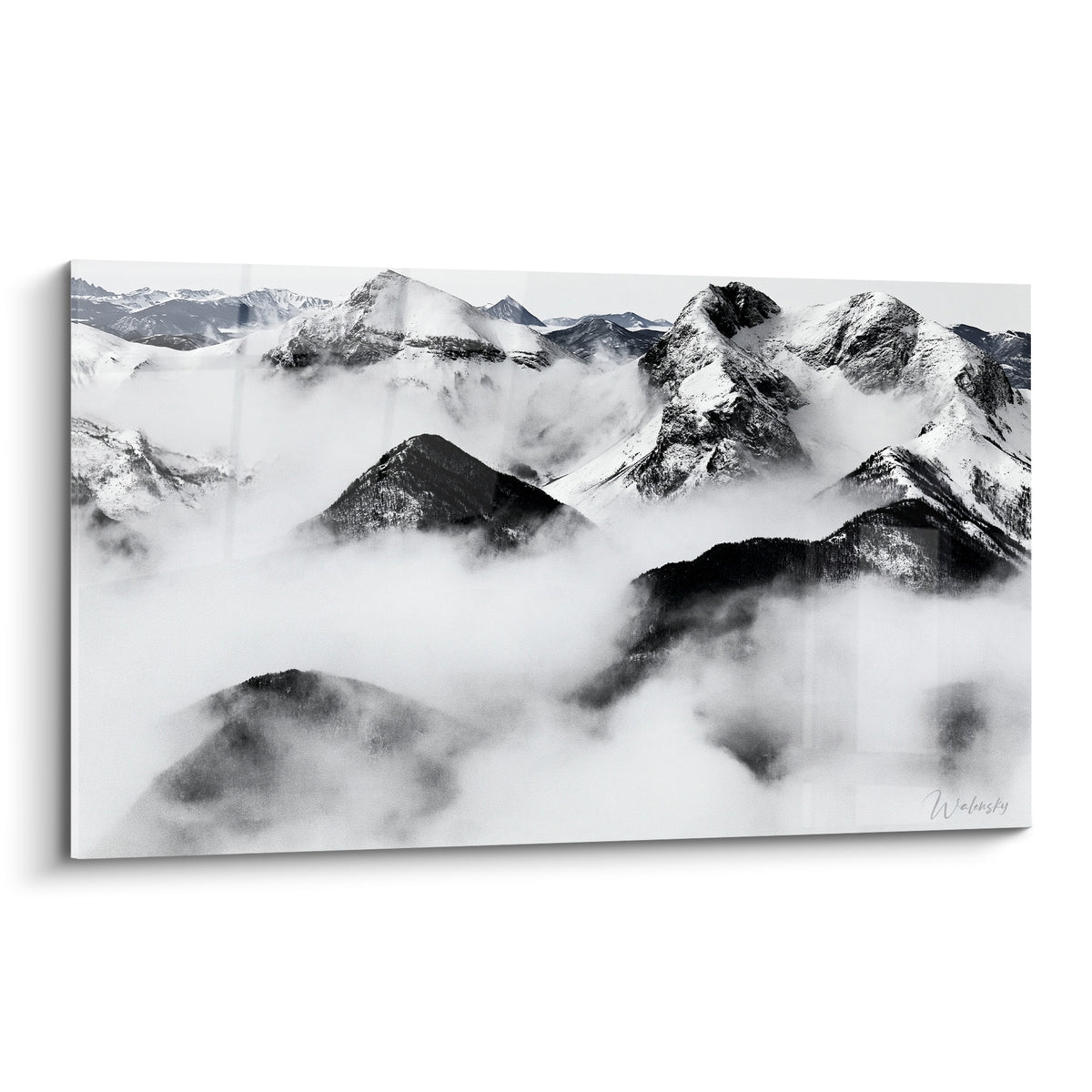 Sommets rocheux enneigés en noir et blanc émergeant d'une épaisse brume grise et blanche