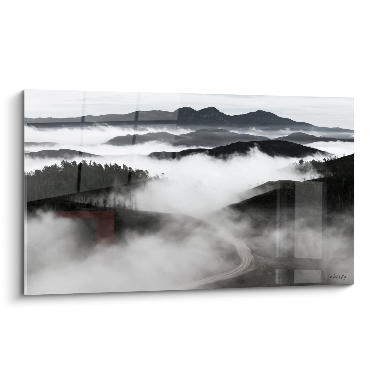 Route de montagne grise et blanche serpentant dans une brume dense et lumineuse