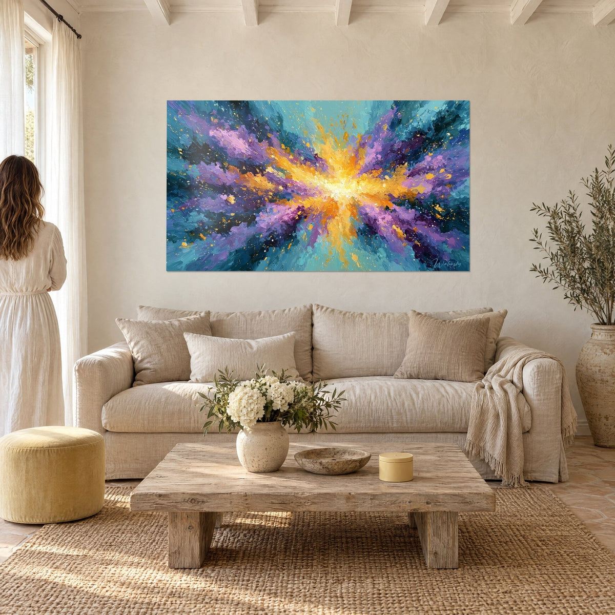 Wall art golden explosion with violet and turquoise shards, seen from behind by a woman above a sofa in a bright living room