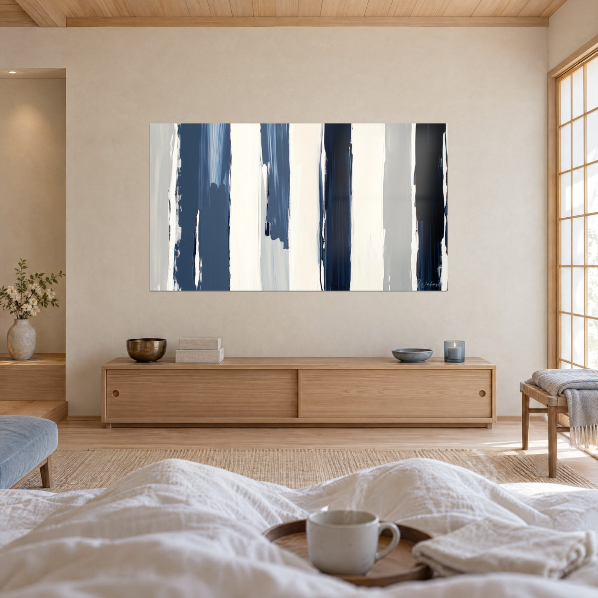 Wall art with geometric painting in indigo and off-white columns, grey accents, above a bed in a bright bedroom