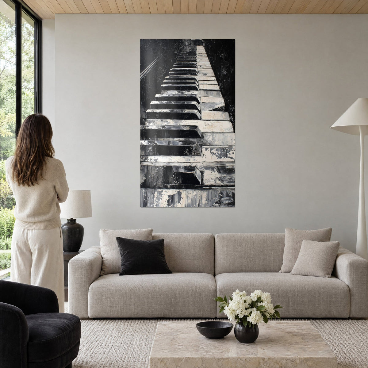Tableau clavier de piano en perspective, touches noires et ivoire écaillées, femme de dos, au-dessus d'un canapé dans un salon lumineux