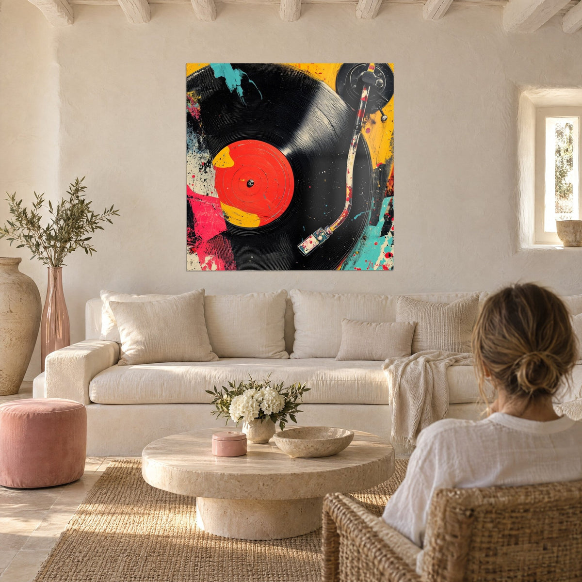 Schilderij zwarte vinylplaat op platenspeler met felrood label, pick-up arm bespat met geel en roze, boven een bank in een lichte woonkamer