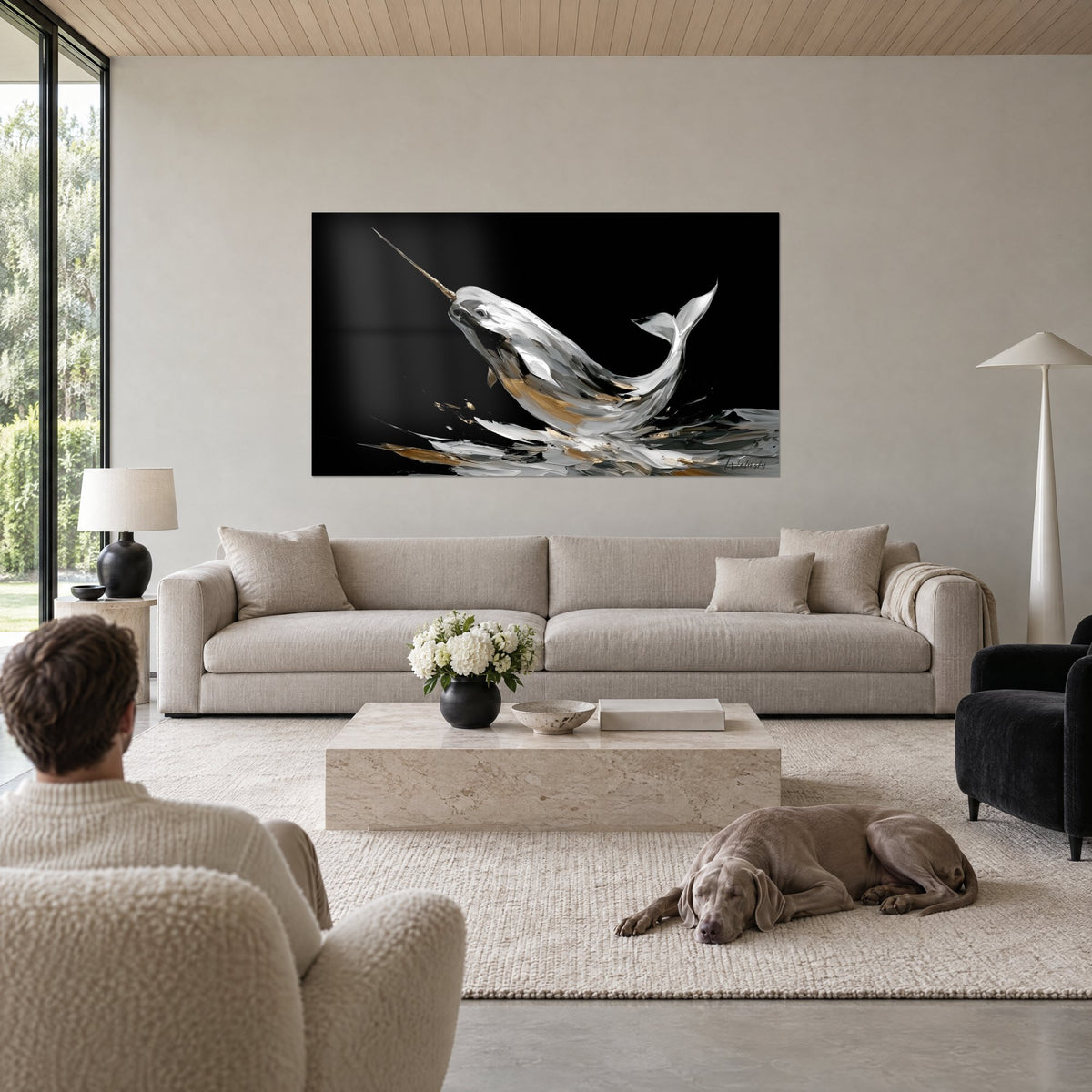 Wall art of a silver narwhal raising its golden tusk on a black background, white and amber palette knife strokes, above a sofa in a bright living room