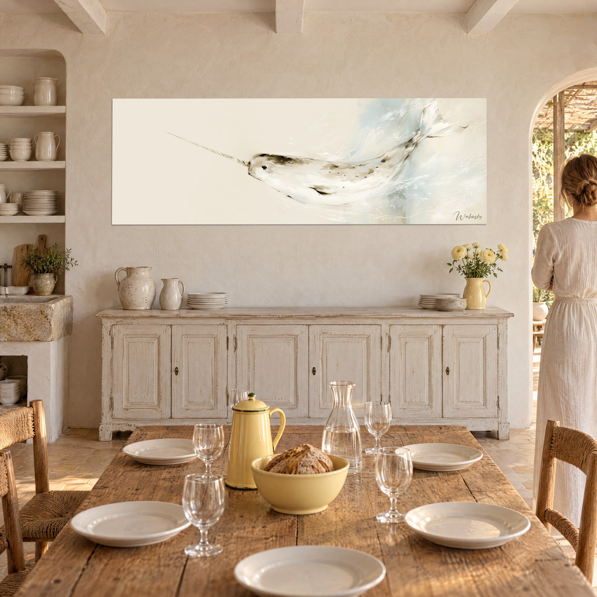 Gemälde tauchendes Polarsäugetier, beige spiralförmiges Horn, himmelblaue Gischt auf cremefarbenem Grund, Frau von hinten neben einem weißen Buffet