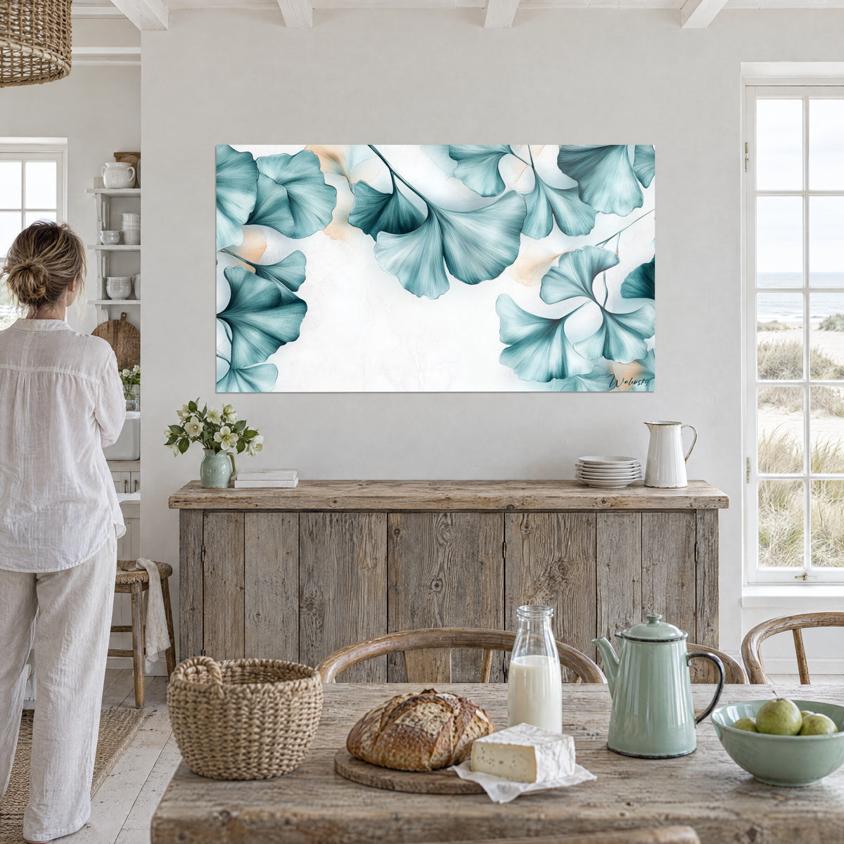 Wall art ginkgo branches in a sea-green and pearly white gradient with peach highlights, facing a weathered wood chest of drawers