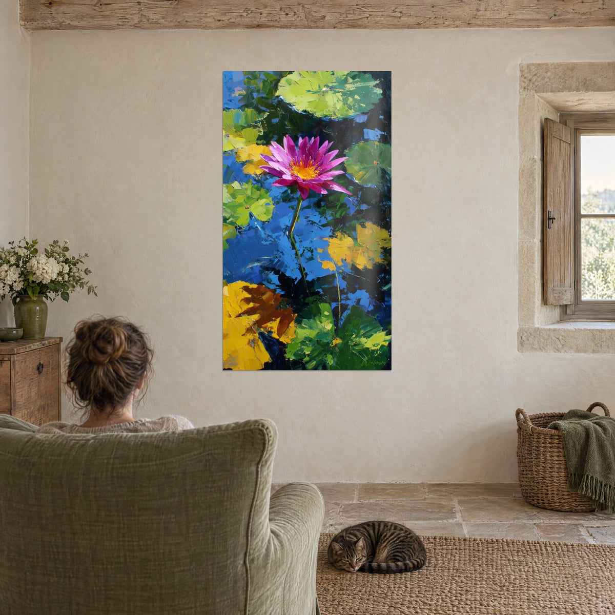 Wall art fuchsia aquatic flower and green water lily leaves lit in yellow, facing the green armchair, a tabby cat sleeping