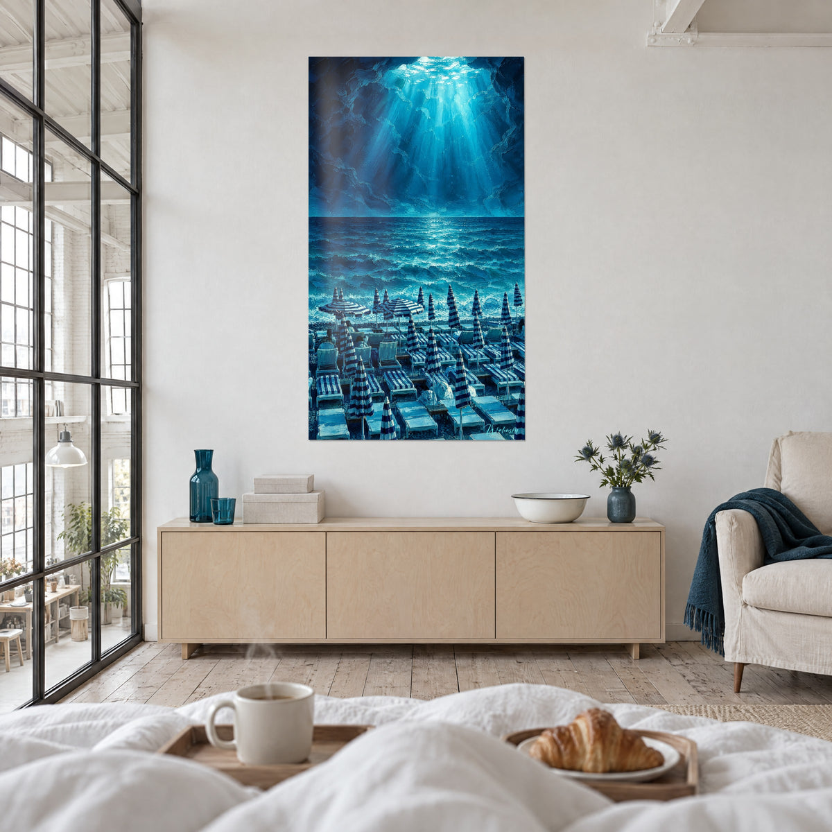 Schilderij Riviera bij het eerste licht, turquoise zee en witte lichtstralen, marineblauwe parasols, boven een bed in een lichte slaapkamer