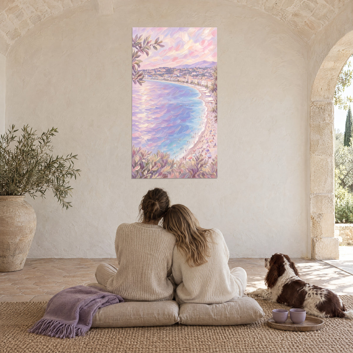Quadro panorama marino di Nizza nelle tonalità pastello, blu turchese e rosa, una coppia di spalle e uno spaniel su dei cuscini