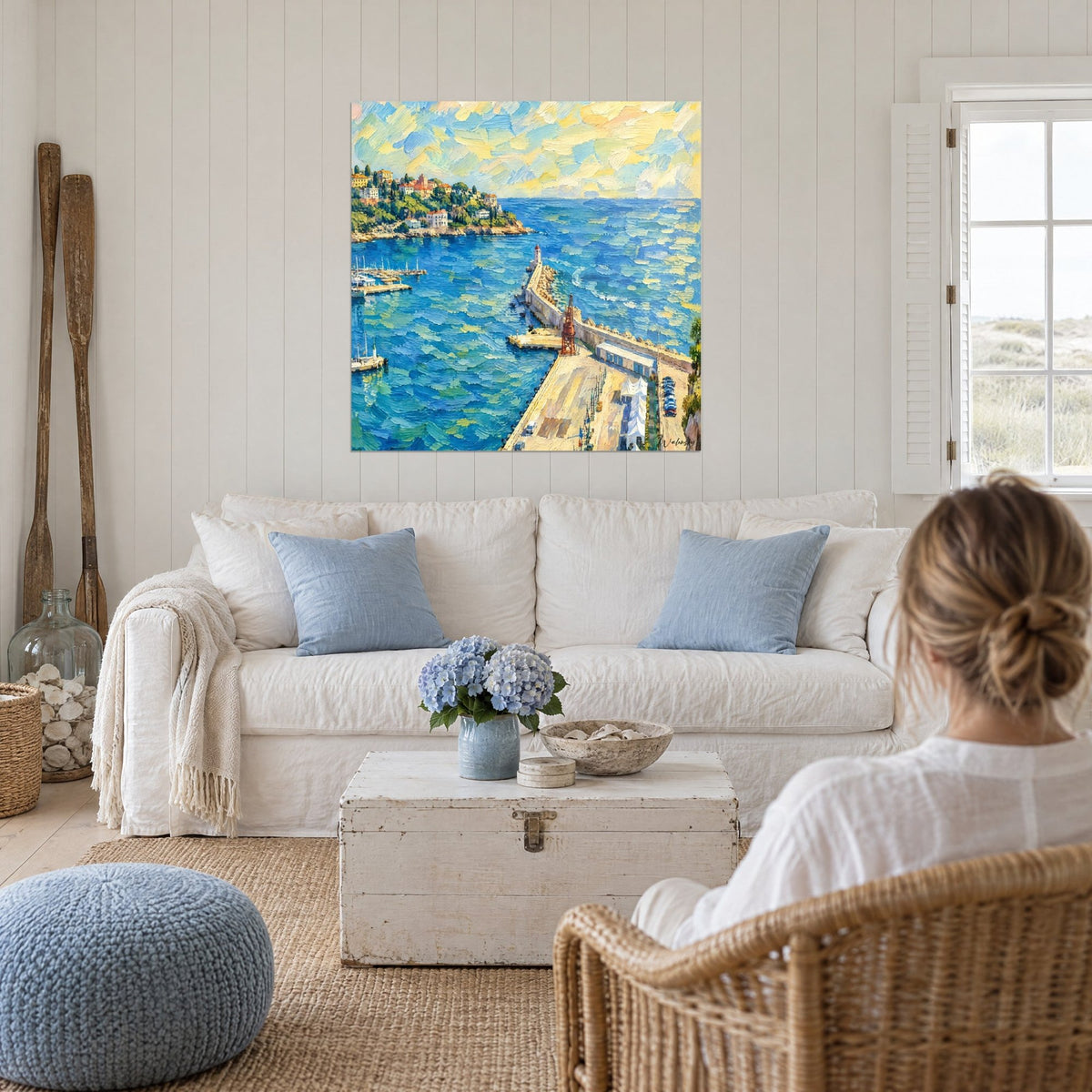 Wall art Mediterranean harbour with red lighthouse, cobalt blue sea and ochre yellow sky, above a sofa in a bright living room