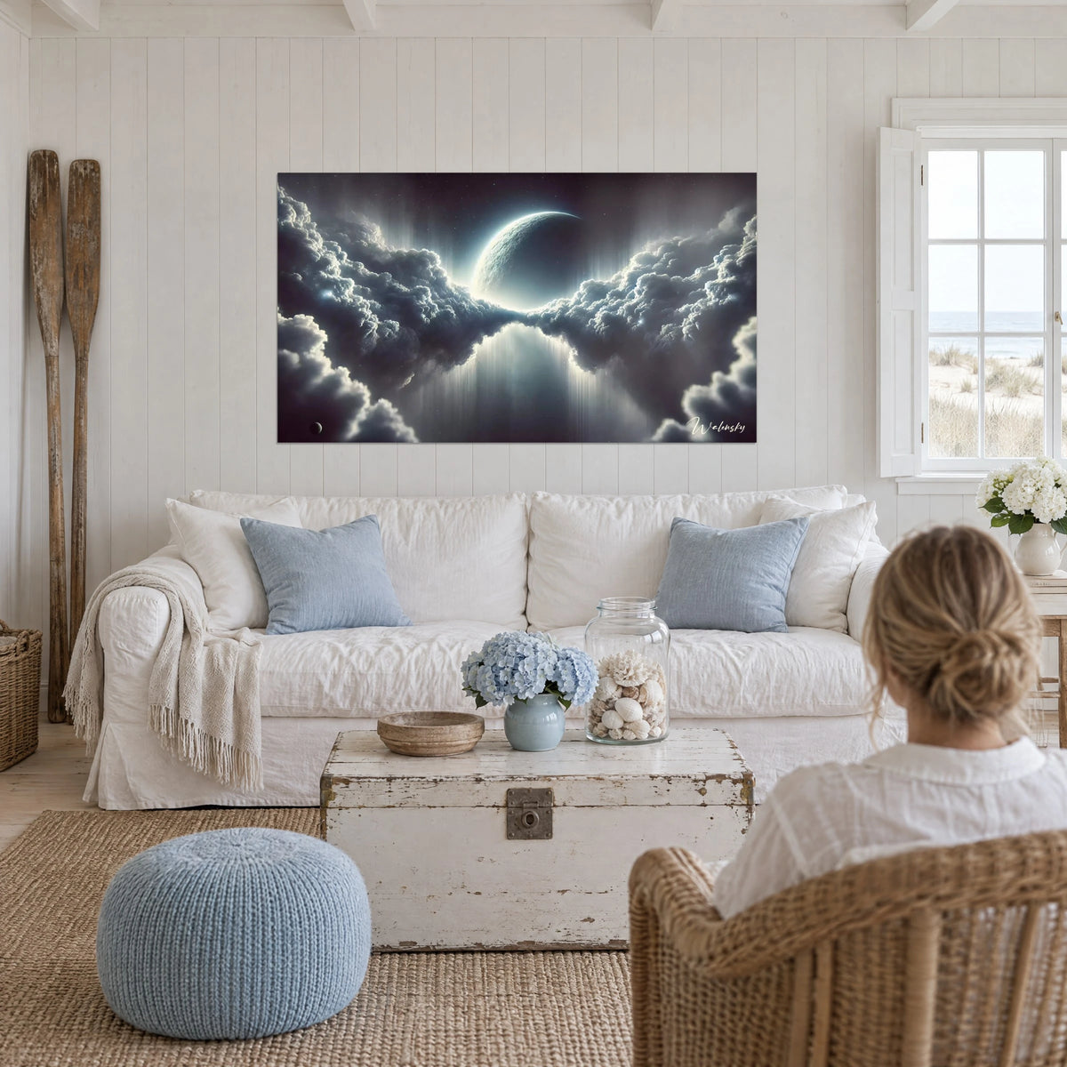 Wall art pearly crescent moon between two anthracite grey cloud masses, above a sofa in a bright living room