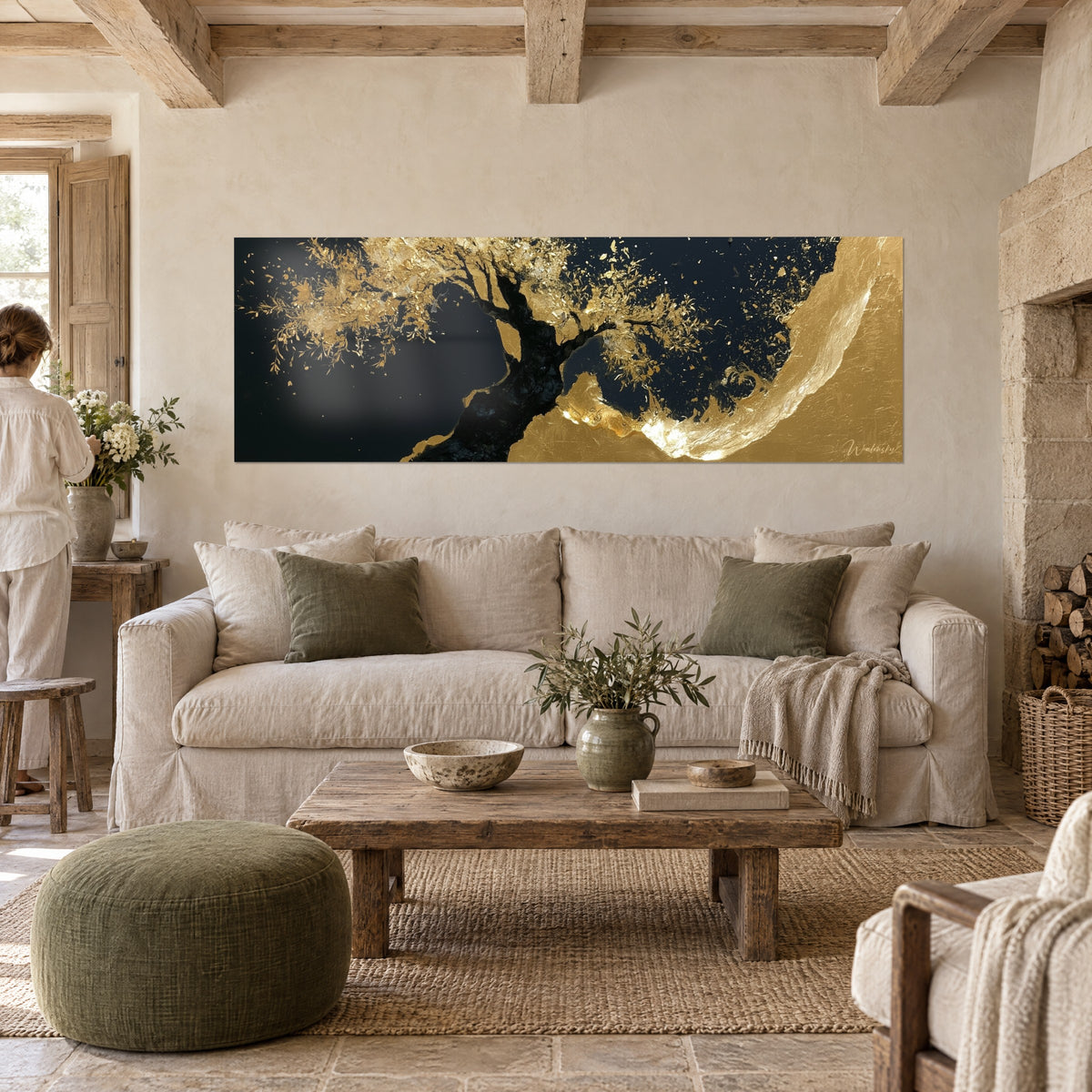 Quadro ulivo con foglie d'oro esplose su fondo nero notte, due persone di spalle, sopra un divano in un soggiorno luminoso