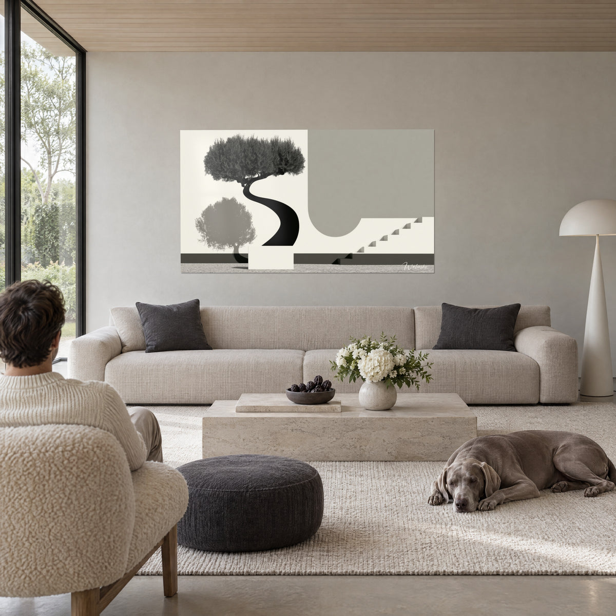 Tableau olivier noir au tronc en S, ombre grise et escalier crème, regardé par deux personnes de dos, au-dessus d'un canapé dans un salon lumineux