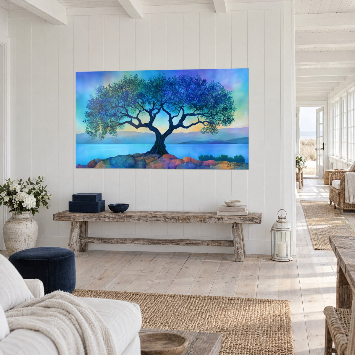 Wall art of a gnarled tree with indigo and emerald foliage facing a turquoise lake, seen three-quarter view on a white hallway wall