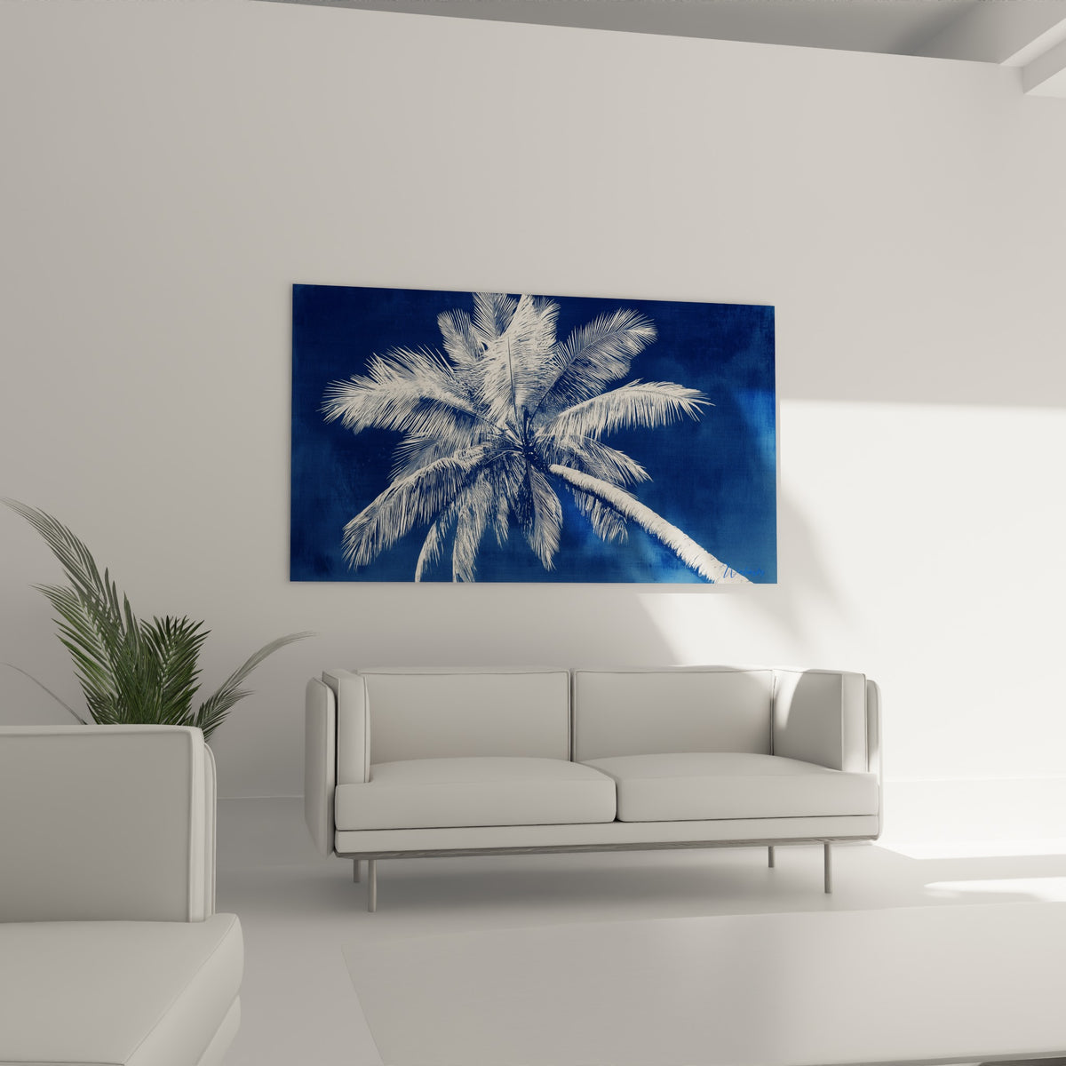 Tronc courbé du palmier en camaïeu bleu et blanc, au-dessus d'un canapé dans un salon lumineux