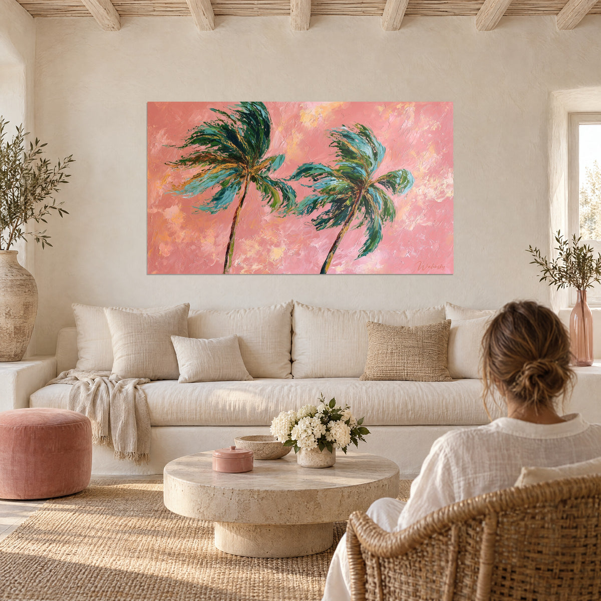 Tableau palmiers penchés au vent, frondes vert émeraude et turquoise sur fond rose corail, au-dessus d'un canapé dans un salon lumineux