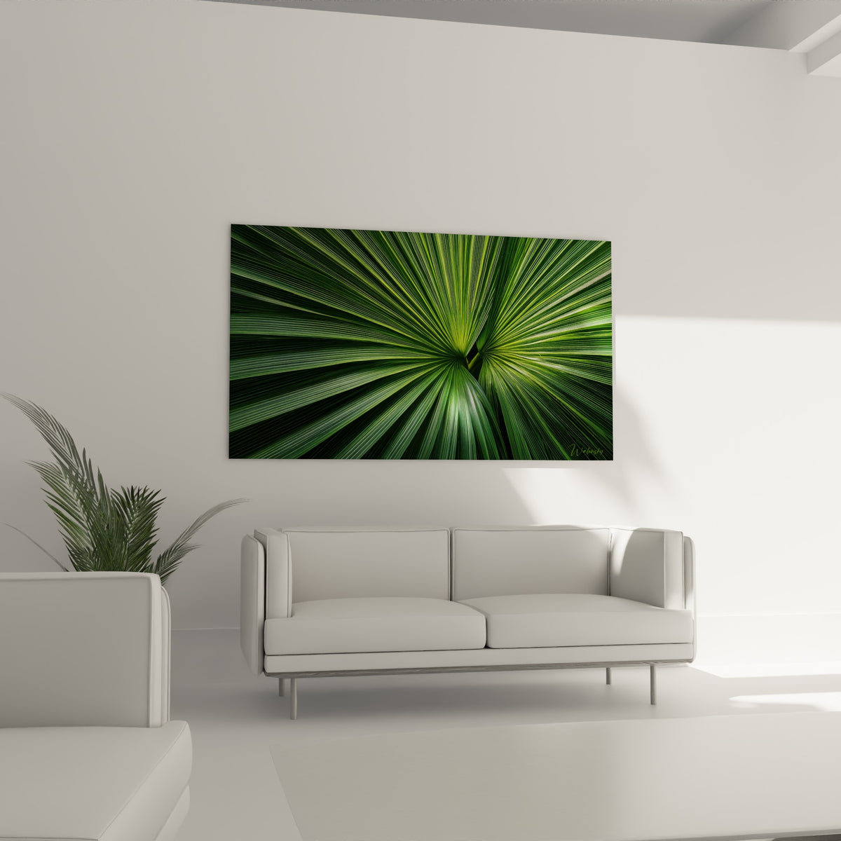 Éventail végétal vert olive et émeraude, disposé au-dessus d'un canapé dans un salon lumineux