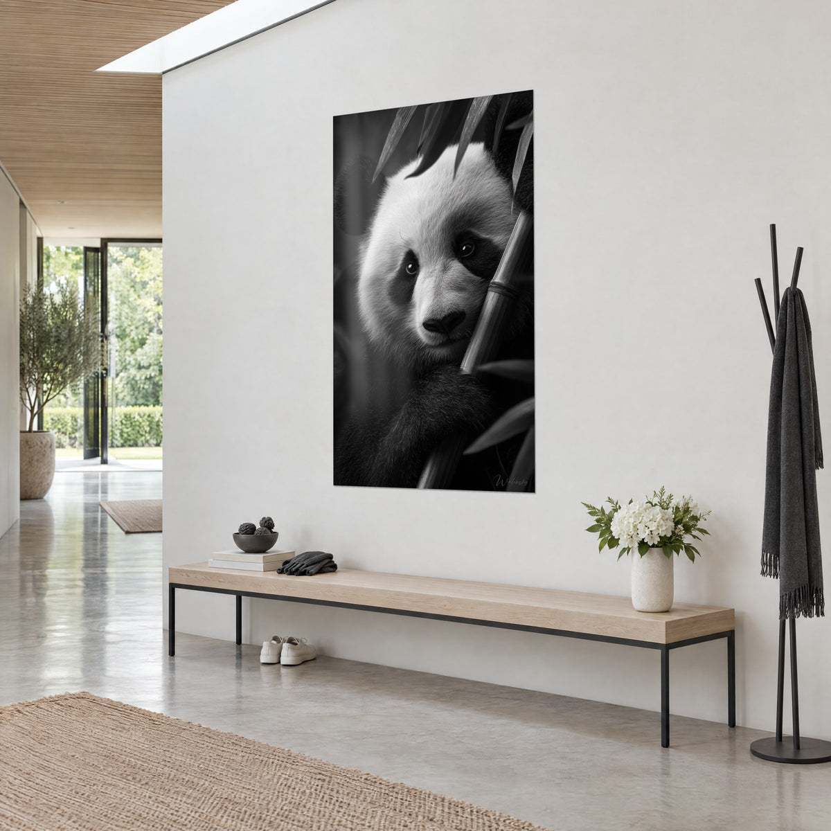 Cuadro de un oso panda de bambú en monocromo, pelaje blanco crema y antifaz negro, hojas afiladas arriba, colgado en un pasillo claro de arquitecto