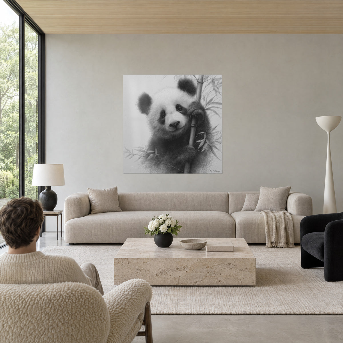 Schilderij pandabeertje in houtskool, zwart-wit vacht, poot om de bamboe geklemd, boven een bank in een lichte woonkamer