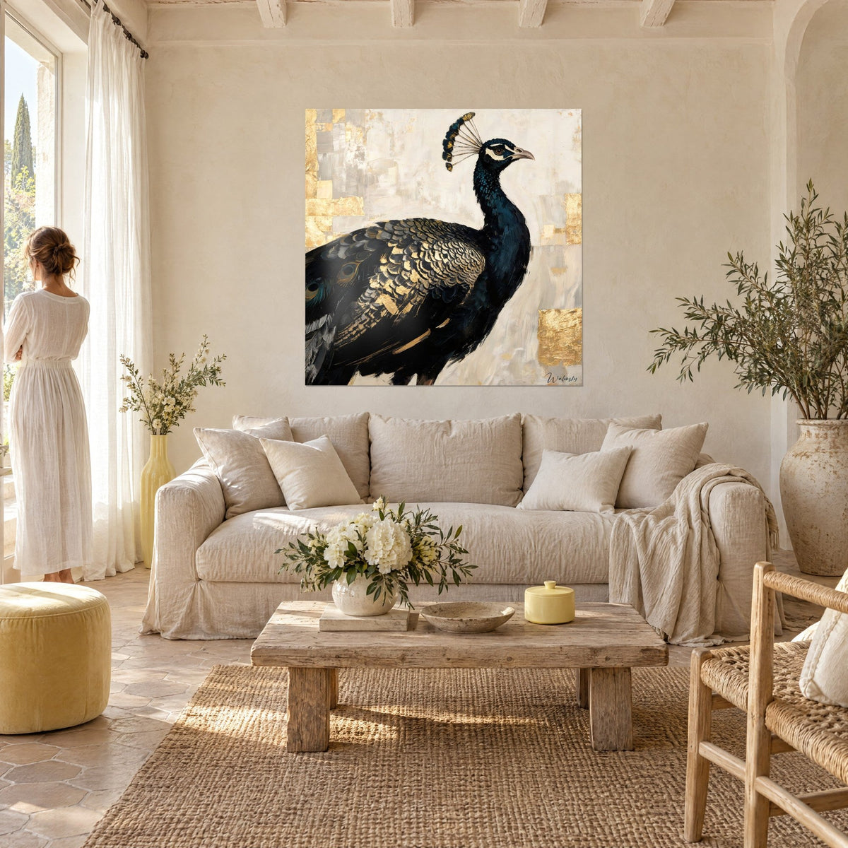 Tableau paon à plumage noir bleuté et or sur fond ivoire, deux personnes de dos, au-dessus d'un canapé dans un salon lumineux