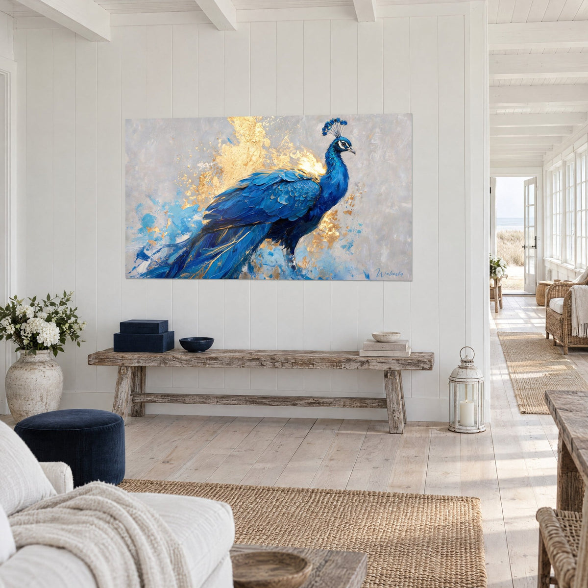 Tableau oiseau royal bleu roi, traînée de feuille d'or et touches turquoise sur fond gris, au mur d'une maison de bord de mer