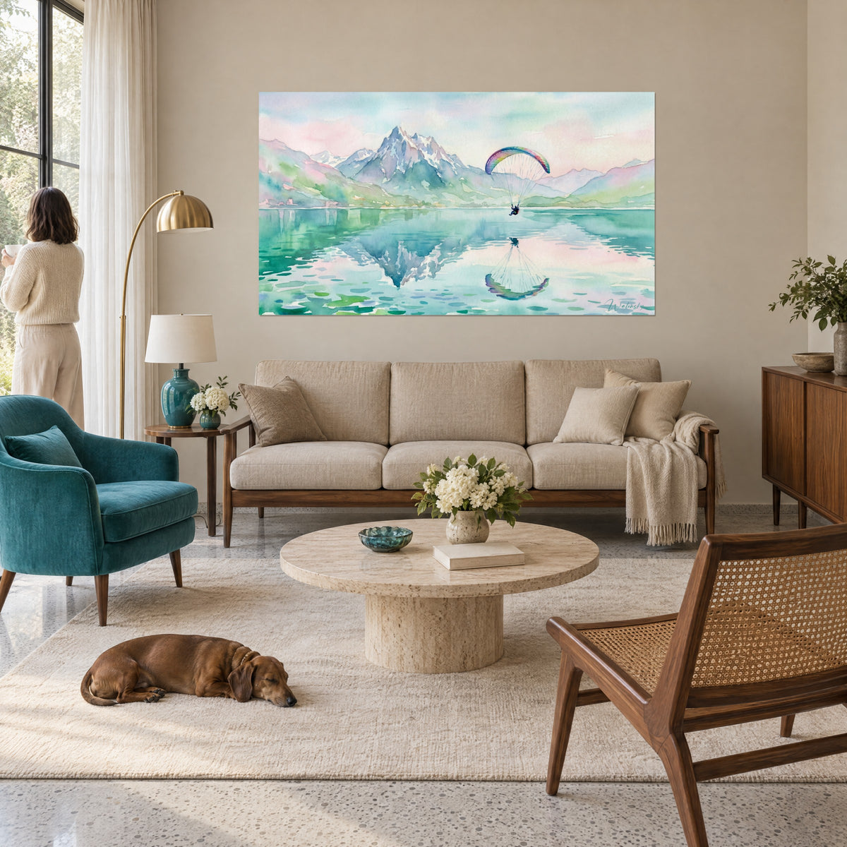 Gemälde eines Gleitschirmfliegers unter einem regenbogenfarbenen Schirm, türkisfarbener See und rosafarbener Gipfel, über einem Sofa in einem hellen Wohnzimmer