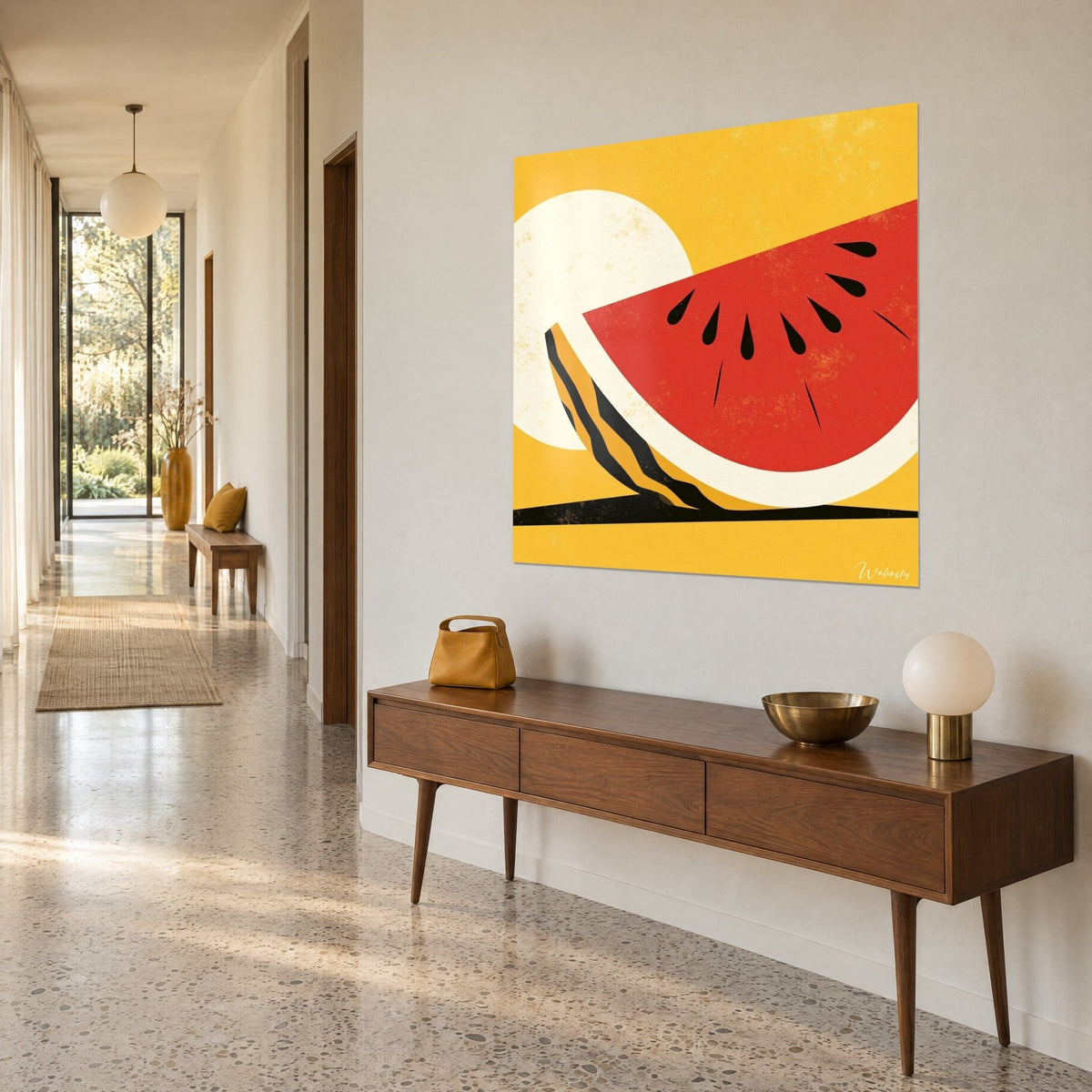 Wall art vivid scarlet watermelon in flat color blocks on an ivory halo and mustard yellow background, hung on a hallway wall, wooden console table